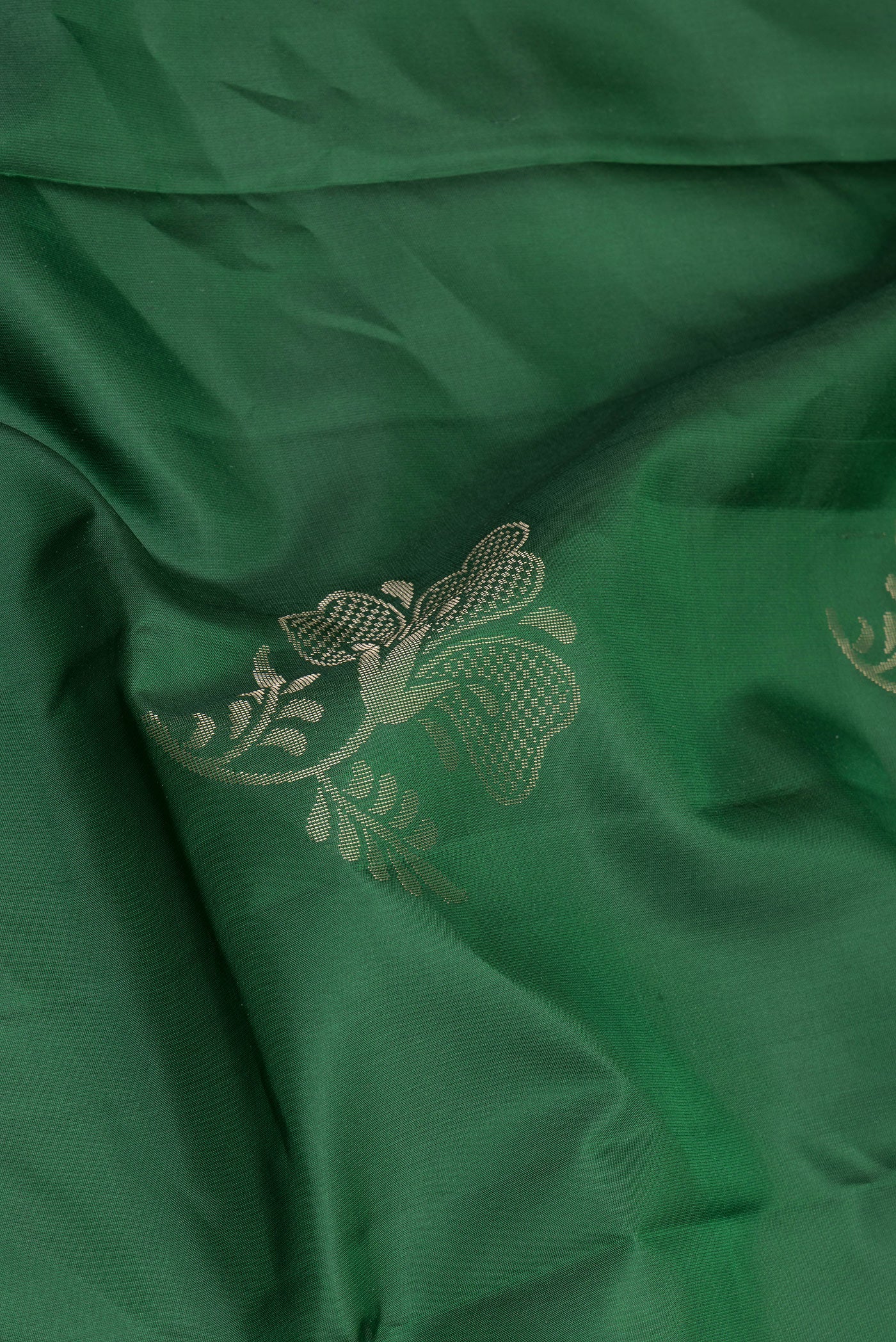 Close up of Bottle Green Soft Silk Saree with Zari Butta on the body and Fancy Border.  displaying folds