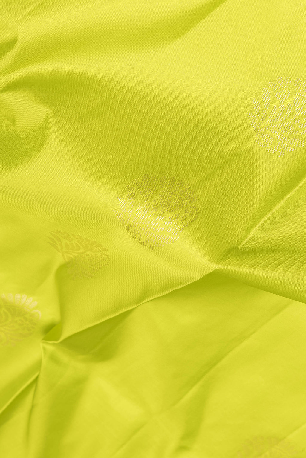Close up of Parrot Green Soft Silk Saree with Zari Butta on the body and Fancy Border.  displaying folds