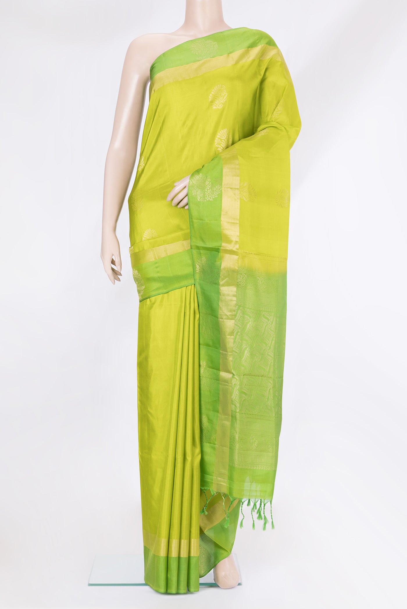 Parrot Green Soft Silk Saree with Zari Butta on the body and Fancy Border.  displayed on a mannequin