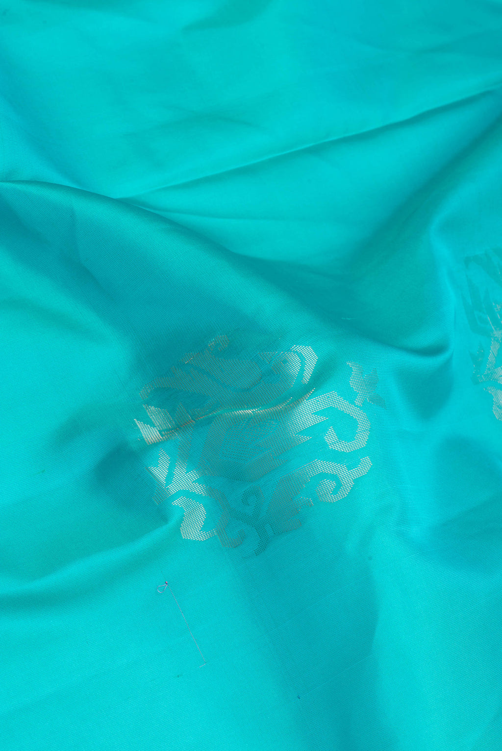 Close up of Sky Blue Soft Silk Saree with Zari Butta on the body and Zari Border.  displaying folds