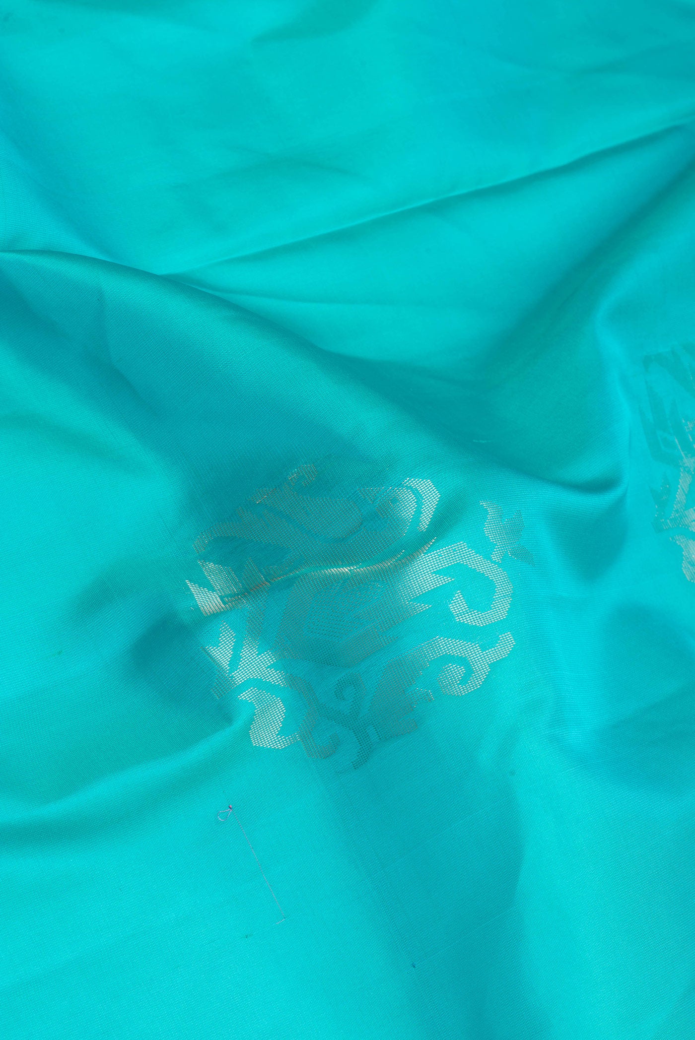 Close up of Sky Blue Soft Silk Saree with Zari Butta on the body and Zari Border.  displaying folds