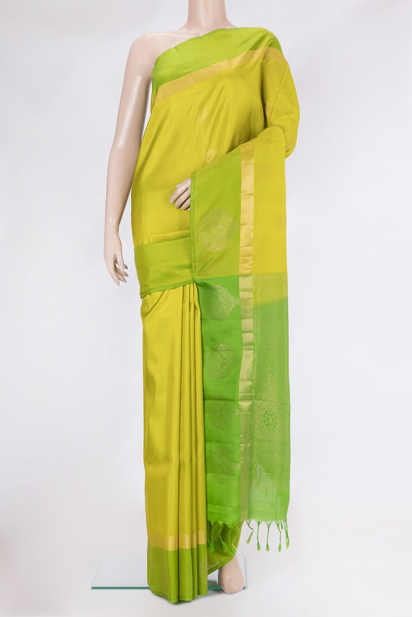 Parrot Green Soft Silk Saree with Zari Butta on the body and Fancy Border.  displayed on a mannequin