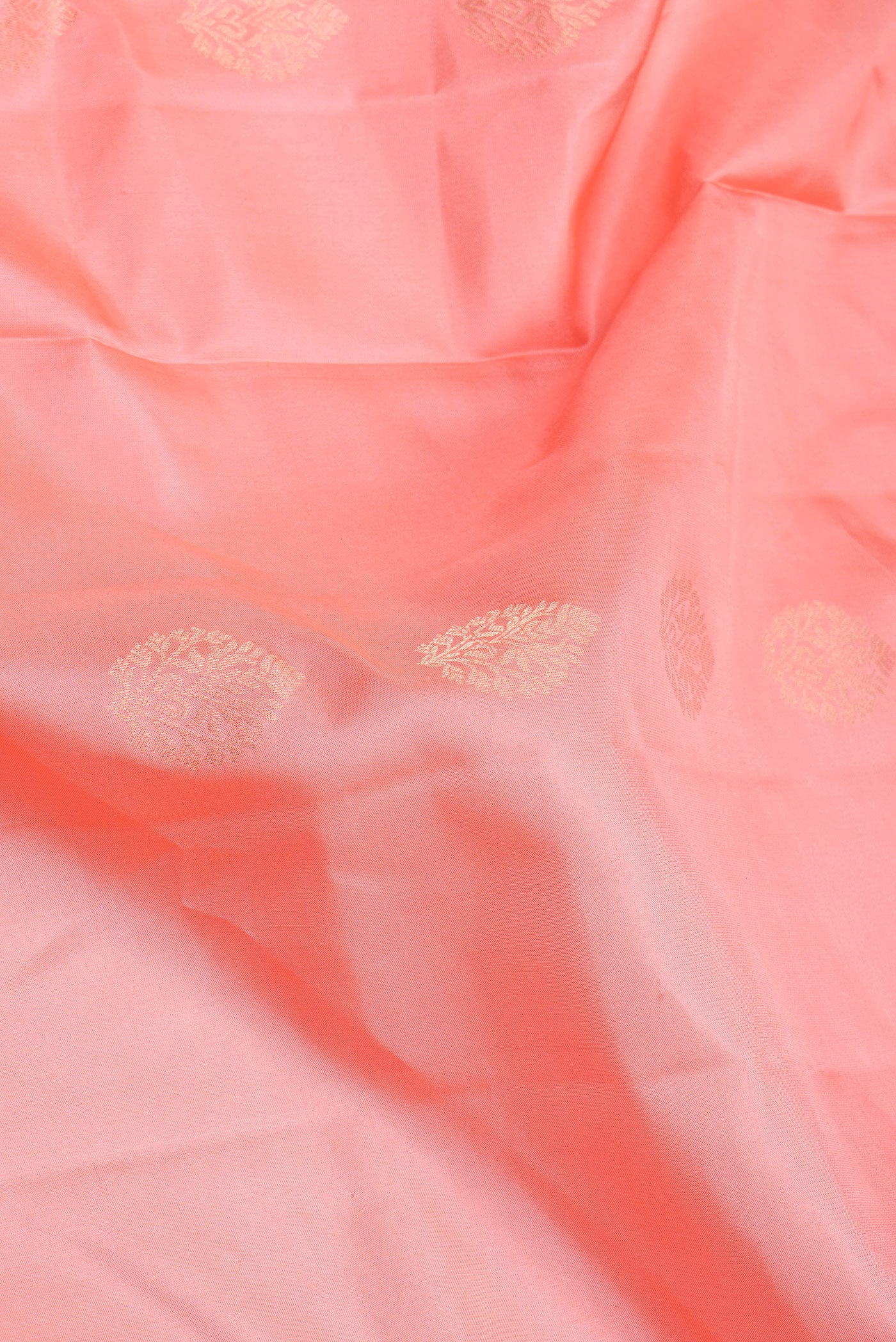Close up of Golden Peach Soft Silk Saree with Zari Butta on the body and Zari Border.  displaying folds