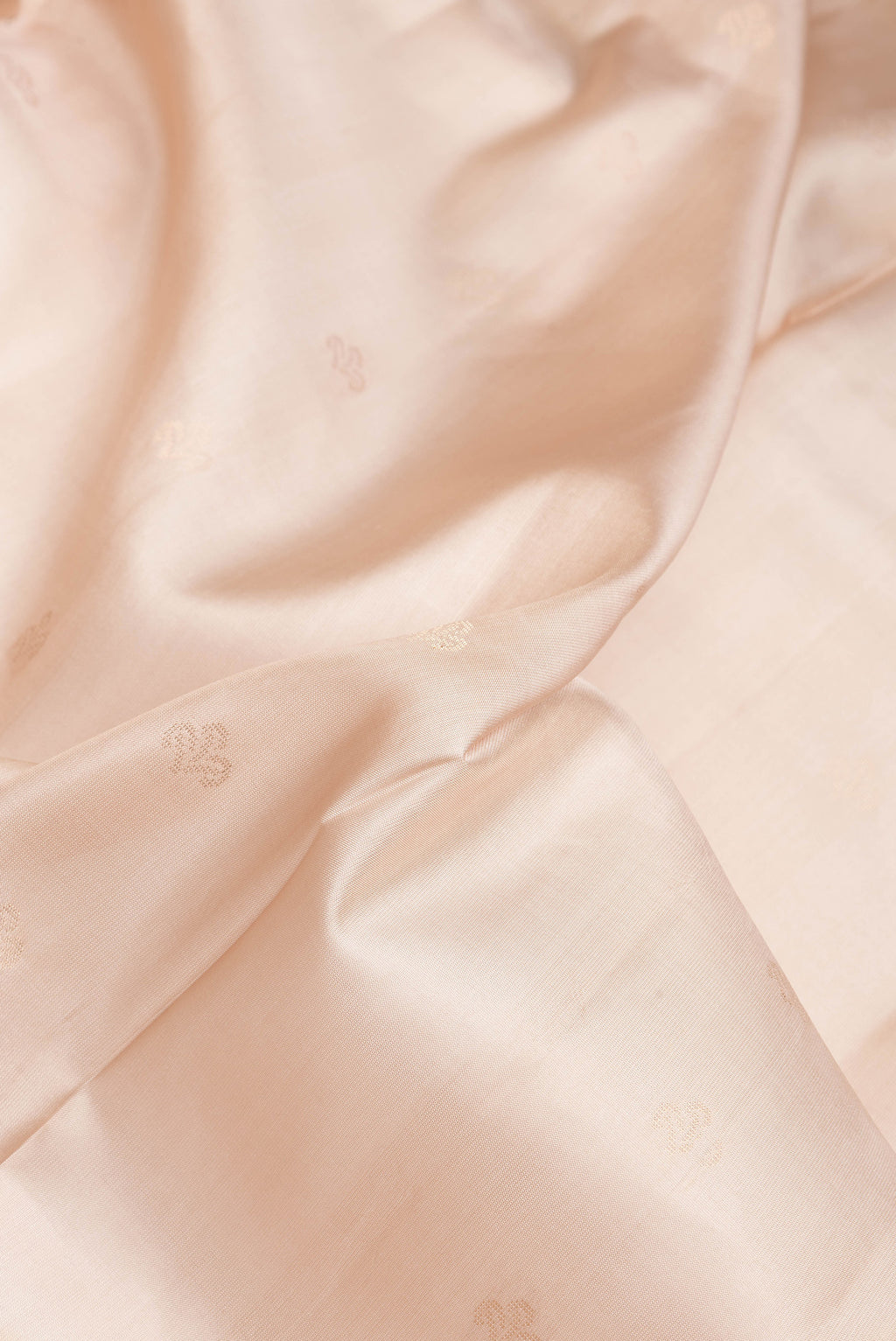 Close up of Beige Dual Tone Soft Silk Saree with Zari Butta on the body and Fancy Border.  displaying folds