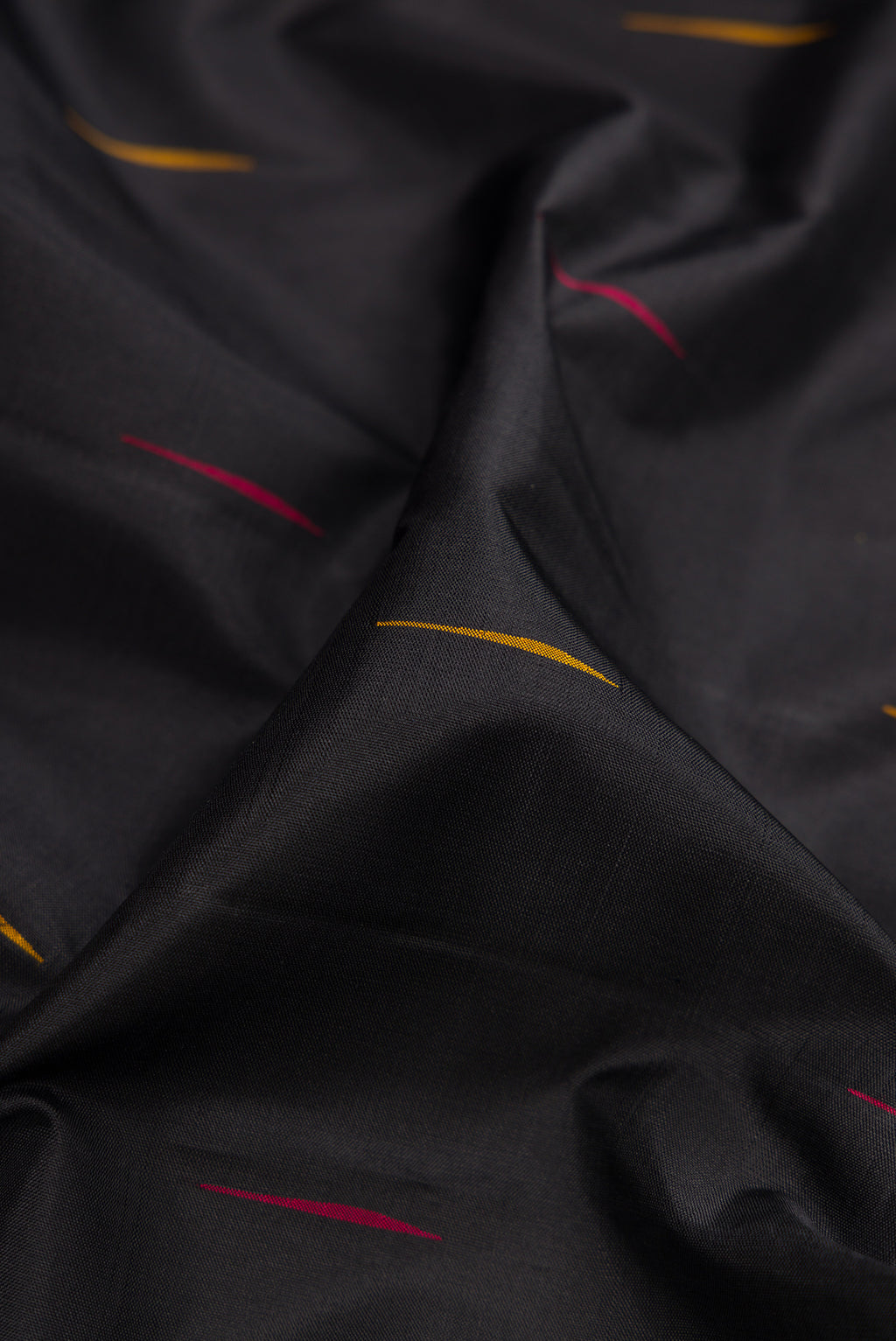 Close up of Black Kanchipuram Silk Saree with Thread Butta on the body and Temple Border.  displaying folds
