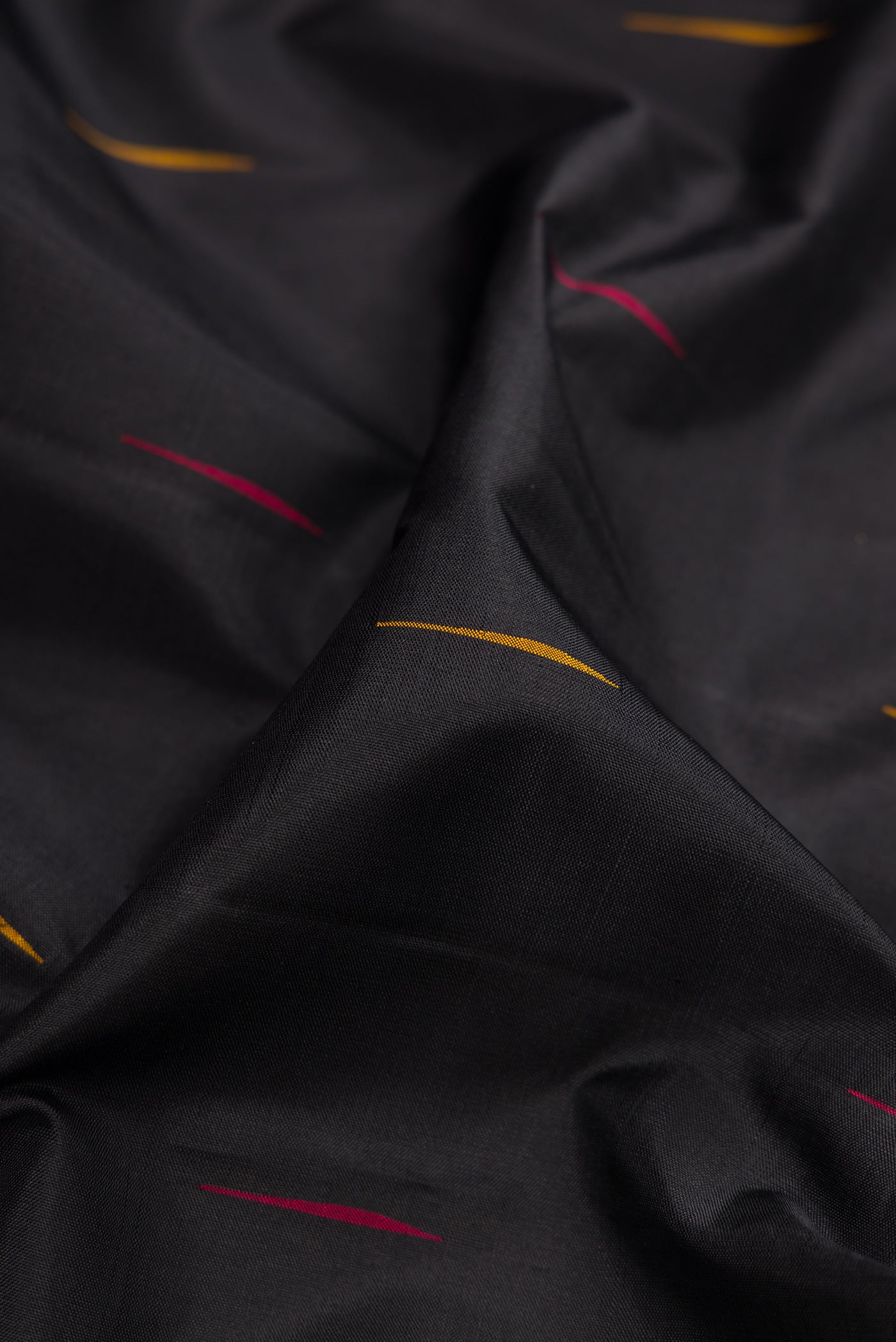 Close up of Black Kanchipuram Silk Saree with Thread Butta on the body and Temple Border.  displaying folds