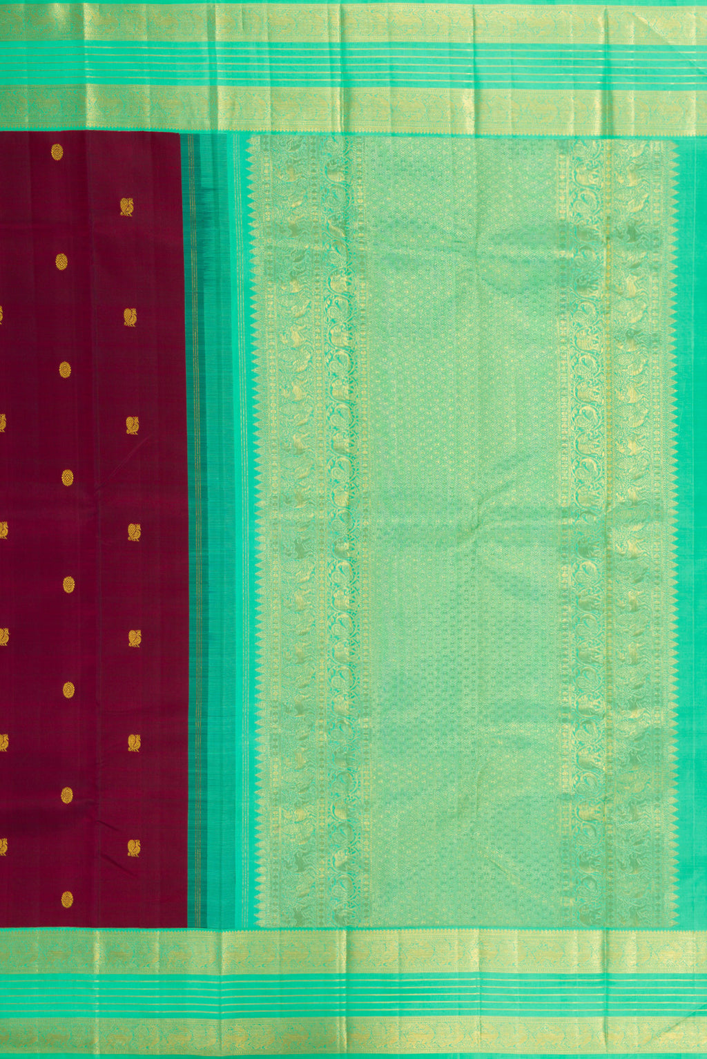 Close up image of the pallu of Maroon Kanjivaram Silk Saree with Zari Butta on the body and Zari Border. 