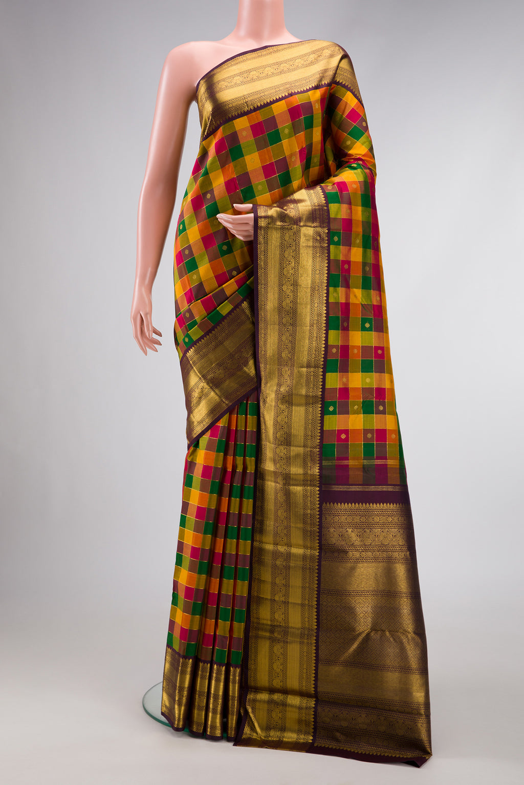 Yellow , Green and Red Color Kanchipuram Silk Saree with Checked design on the body and Zari Border.  displayed on a mannequin