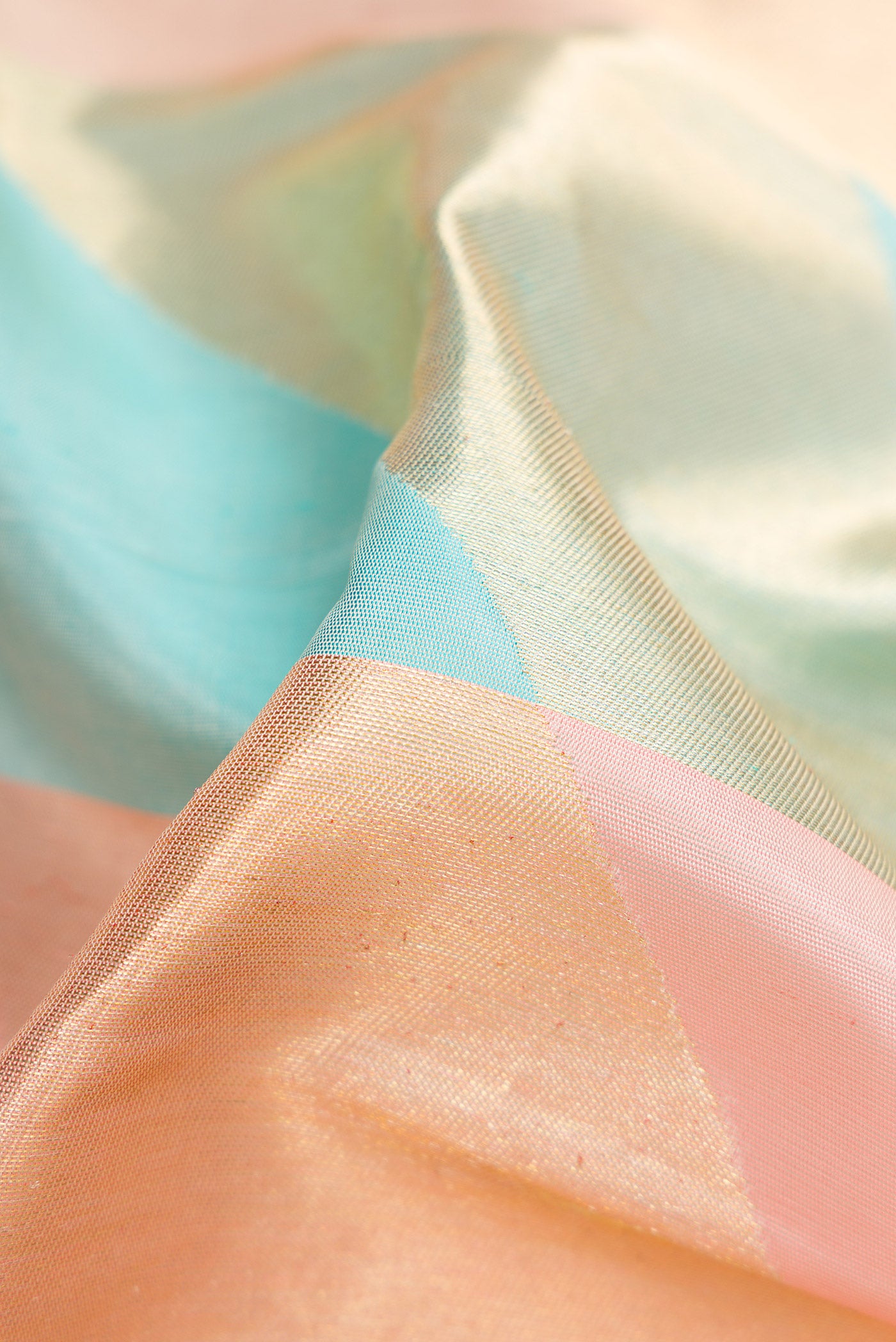 Close up of Peach Dual Tone Kanchipuram Silk Saree with Zari Brocade on the body and Fancy Border.  displaying folds