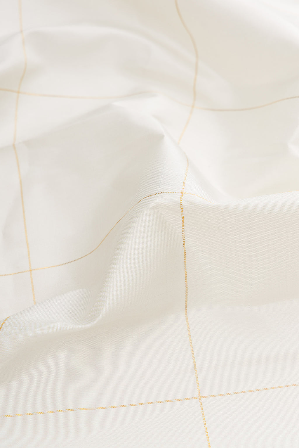 Close up of White Dual Tone Kanchipuram Silk Saree with Checked design on the body and Fancy Border.  displaying folds