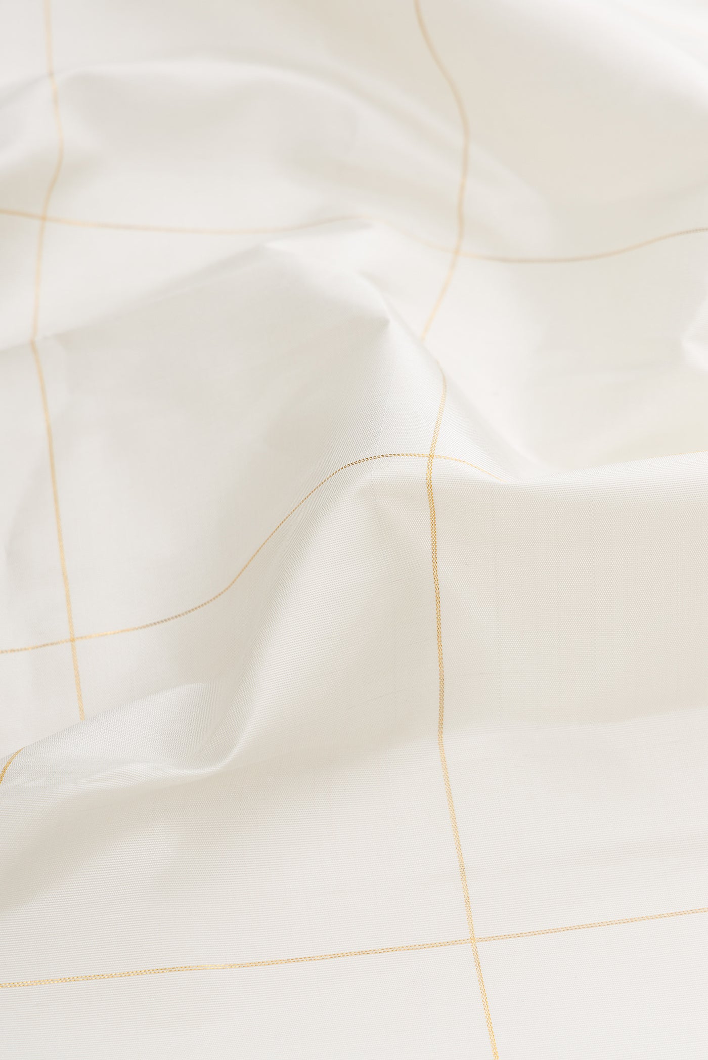 Close up of White Dual Tone Kanchipuram Silk Saree with Checked design on the body and Fancy Border.  displaying folds