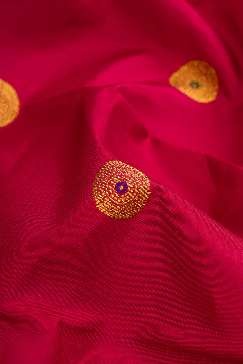 Close up of Maroon Kanchipuram Silk Saree with Zari And Thread Butta on the body and Thin Zari Line.  displaying folds