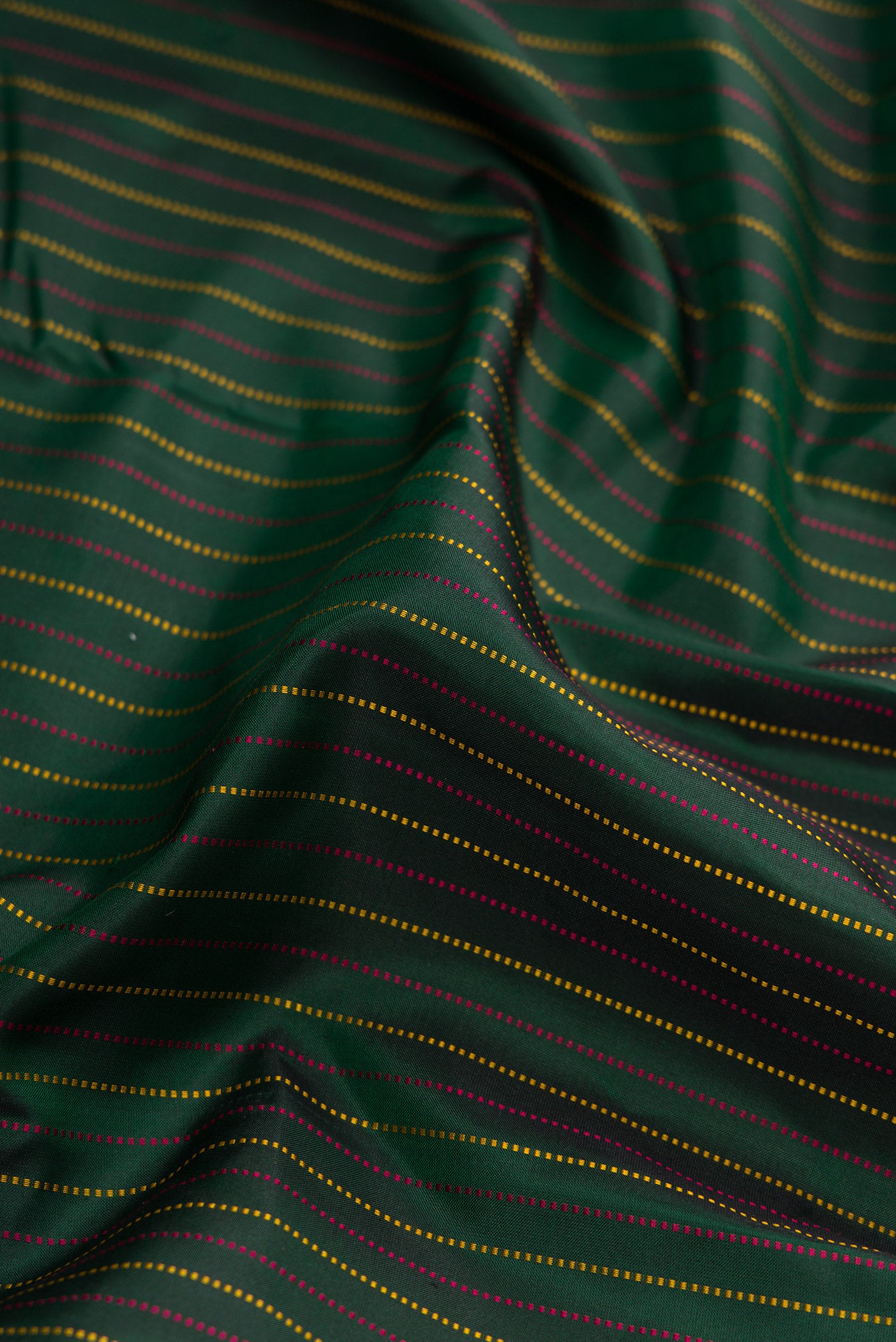 Close up of Bottle Green Dual Tone Kanchipuram Silk Saree with Stripes on the body and Zari Border.  displaying folds