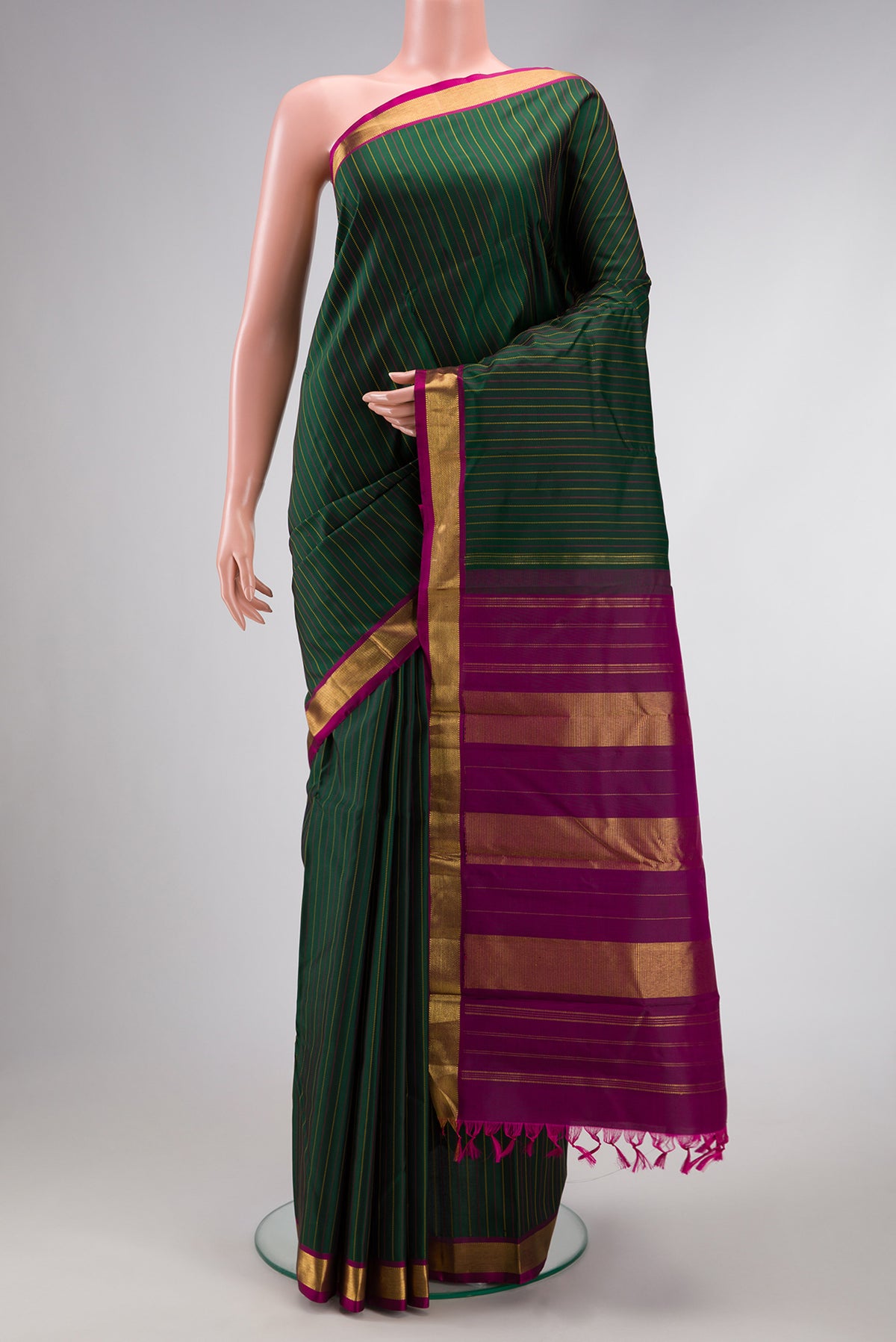 Bottle Green Dual Tone Kanchipuram Silk Saree with Stripes on the body and Zari Border.  displayed on a mannequin