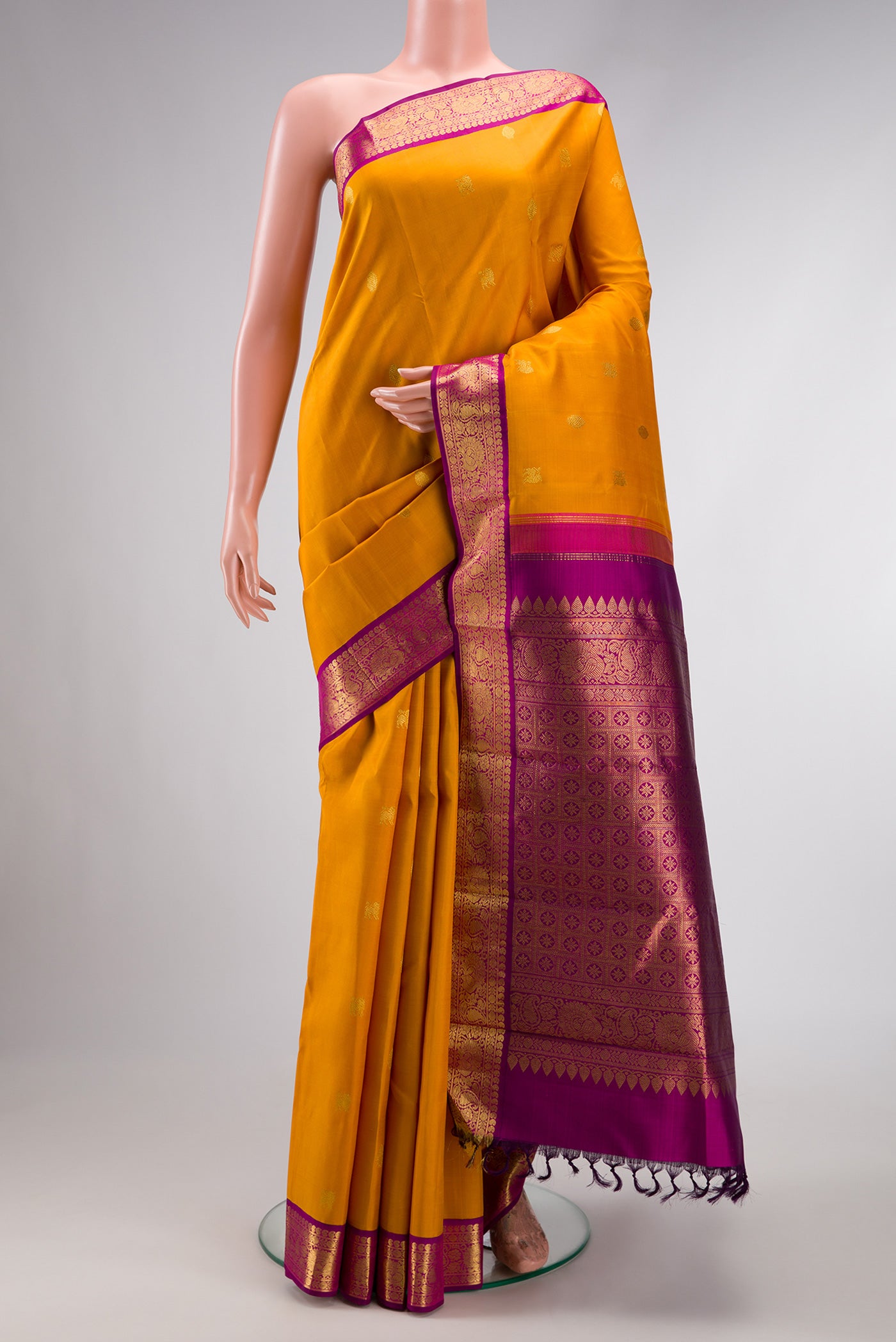 Mustard Dual Tone Kanjivaram Silk Saree with Zari Butta on the body and Zari Border.  displayed on a mannequin