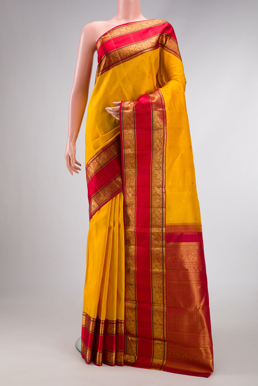 Yellow Dual Tone Kanchipuram Silk Saree with Zari Butta on the body and Zari Border.  displayed on a mannequin