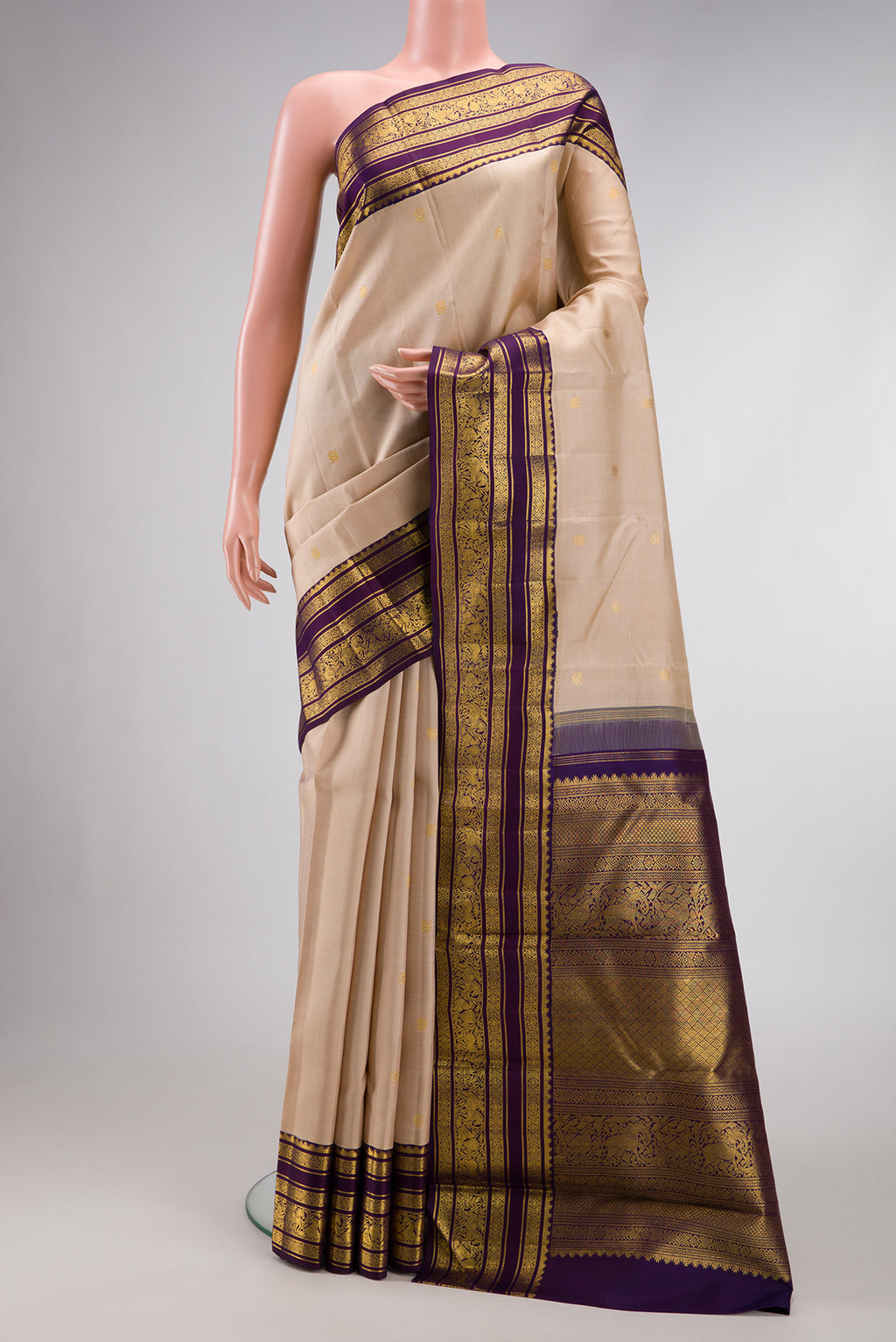 Beige Dual Tone Kanchipuram Silk Saree with Zari Butta on the body and Zari Border.  displayed on a mannequin