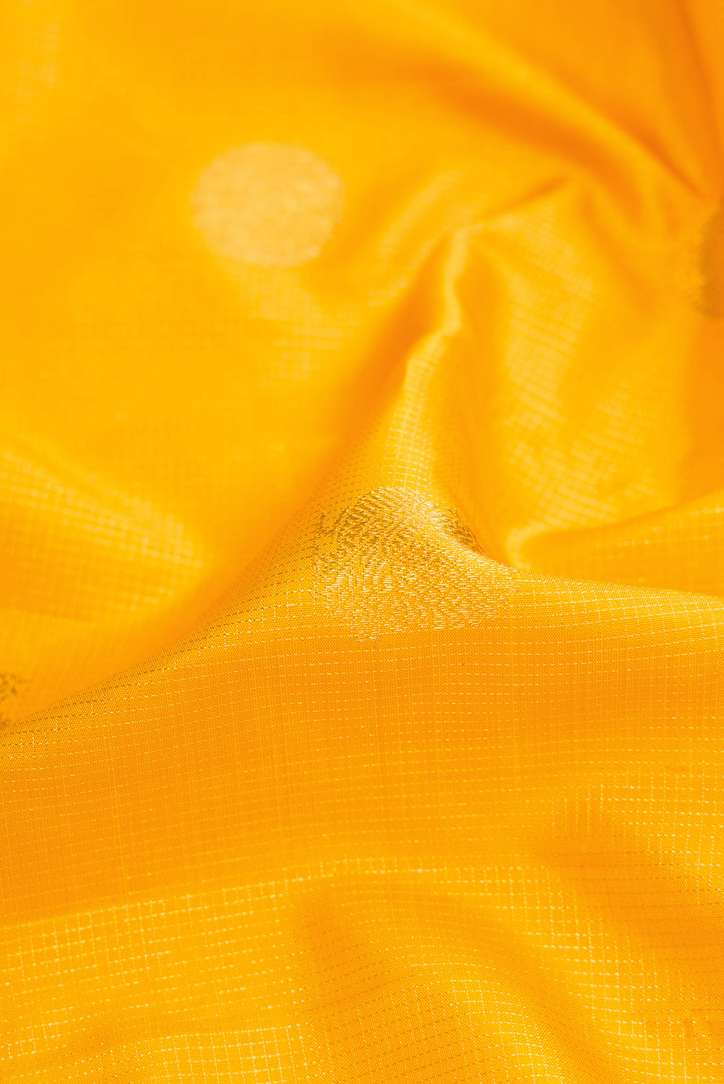 Close up of Yellow Dual Tone Kanchipuram Silk Saree with Zari Butta on the body and Zari Border.  displaying folds