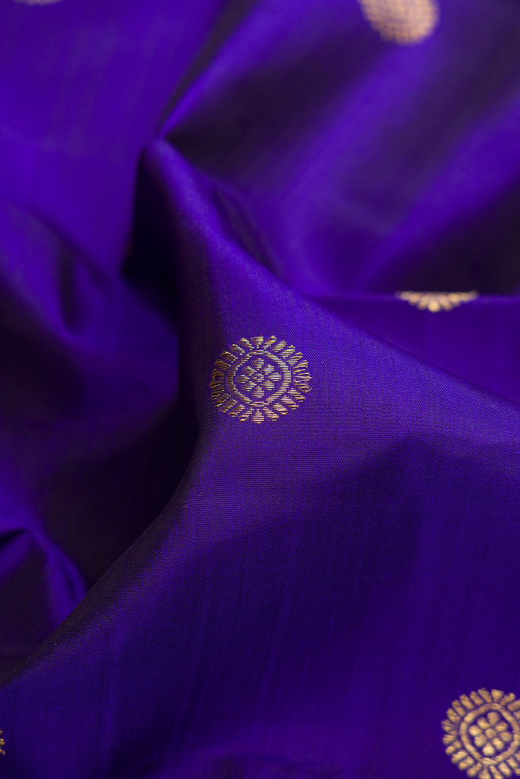 Close up of Royal Blue Dual Tone Kanchipuram Silk Saree with Zari Butta on the body and Zari Border.  displaying folds