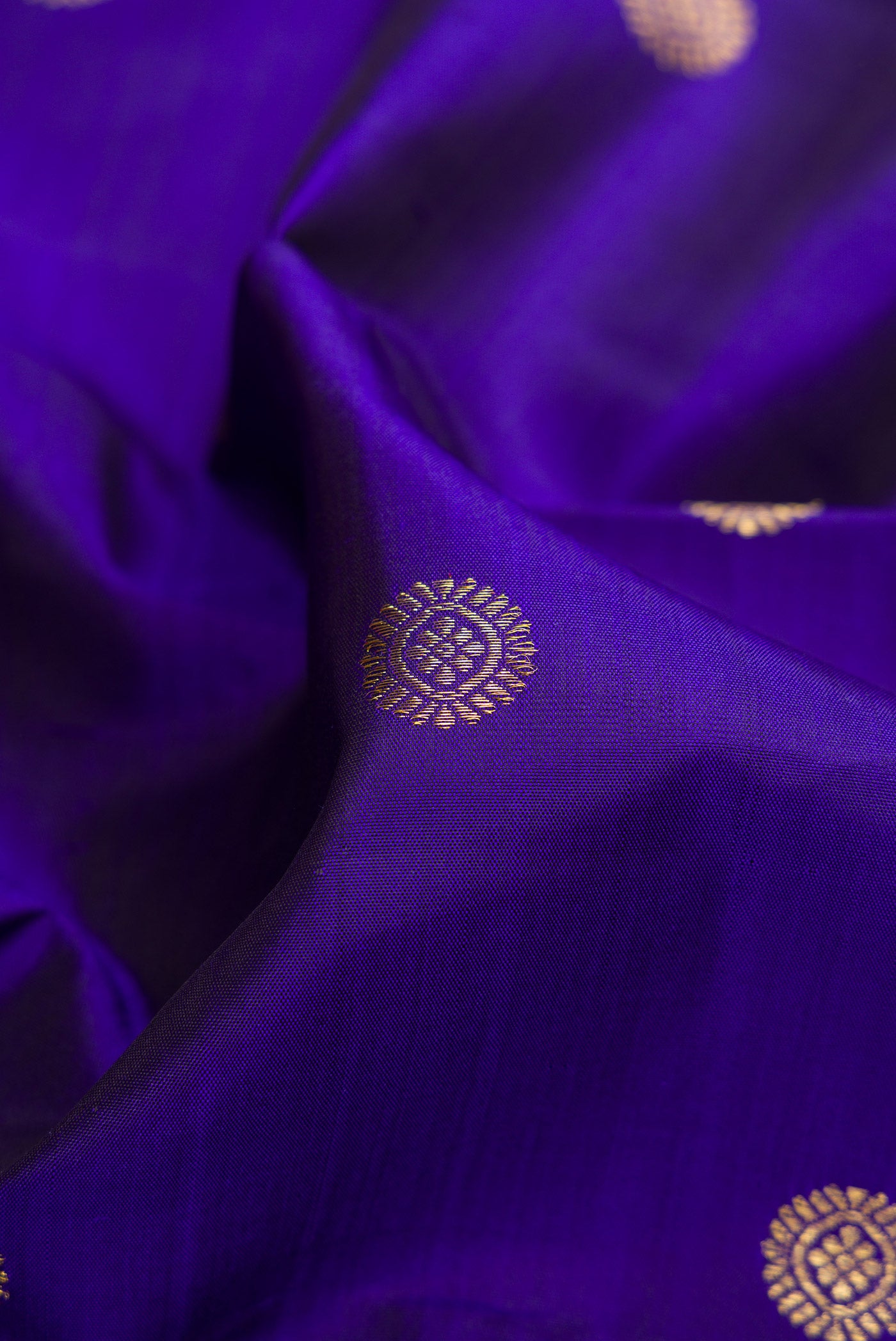 Close up of Royal Blue Dual Tone Kanchipuram Silk Saree with Zari Butta on the body and Zari Border.  displaying folds
