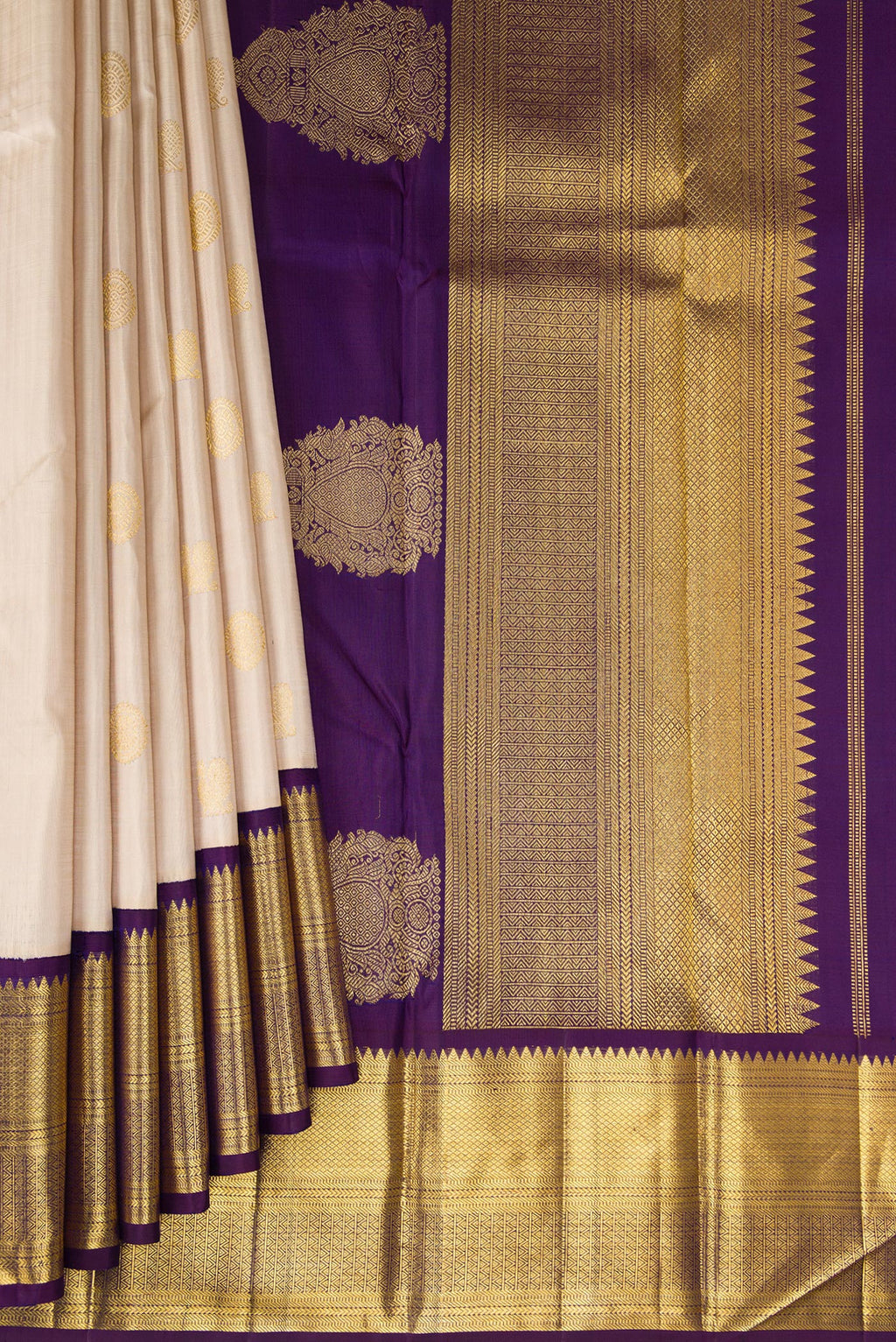 Pleats and pallu of Beige Kanchipuram Silk Saree with Zari Butta on the body and Zari Border. 