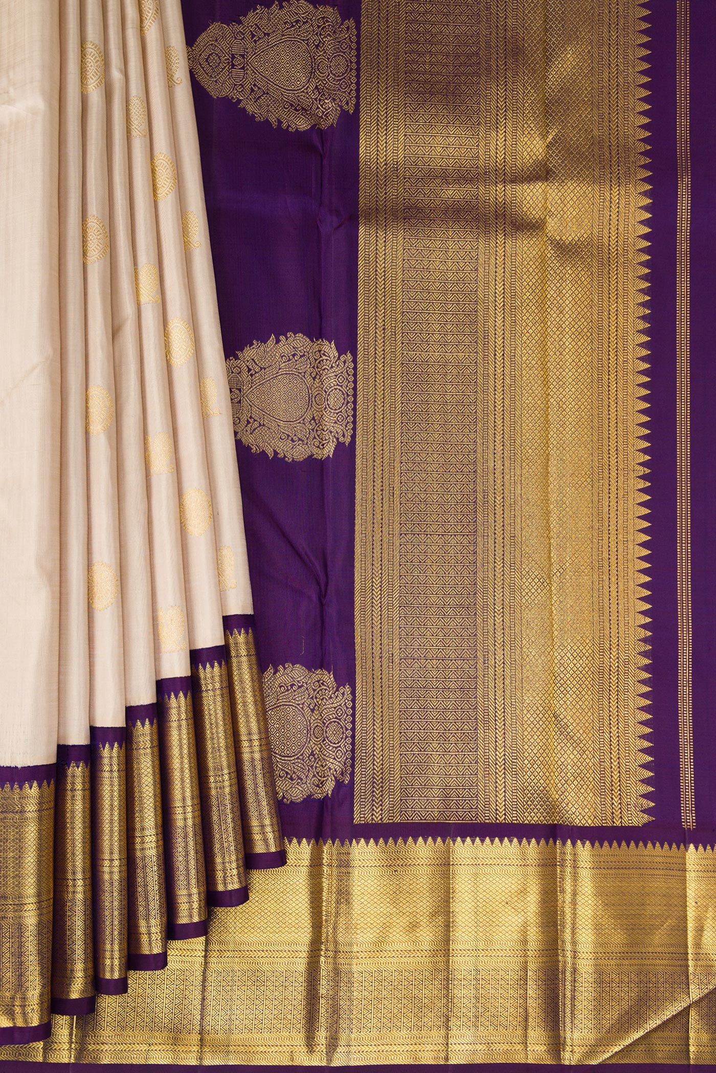 Pleats and pallu of Beige Kanchipuram Silk Saree with Zari Butta on the body and Zari Border. 