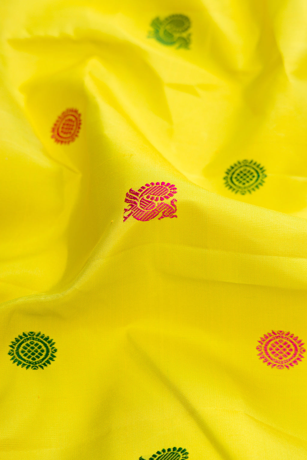 Close up of Pure Silk Pure Zari Lemon Yellow Dual Tone Kanjivaram Saree with Thread Butta on the body and Ganga Jamuna Border.  displaying folds