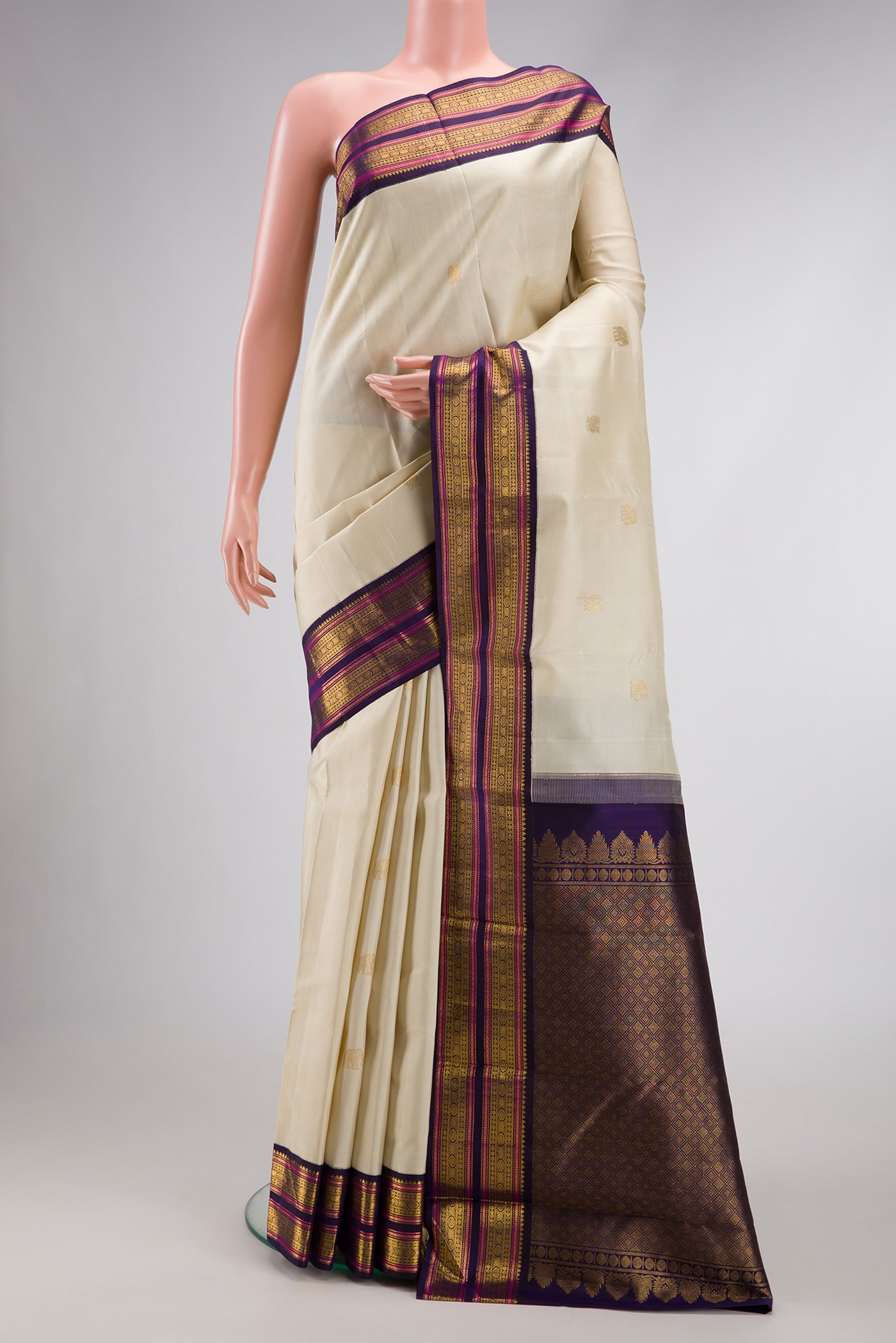 Pure Silk Pure Zari Off White Dual Tone Kanjivaram Saree with Zari Butta on the body and Zari Border.  displayed on a mannequin