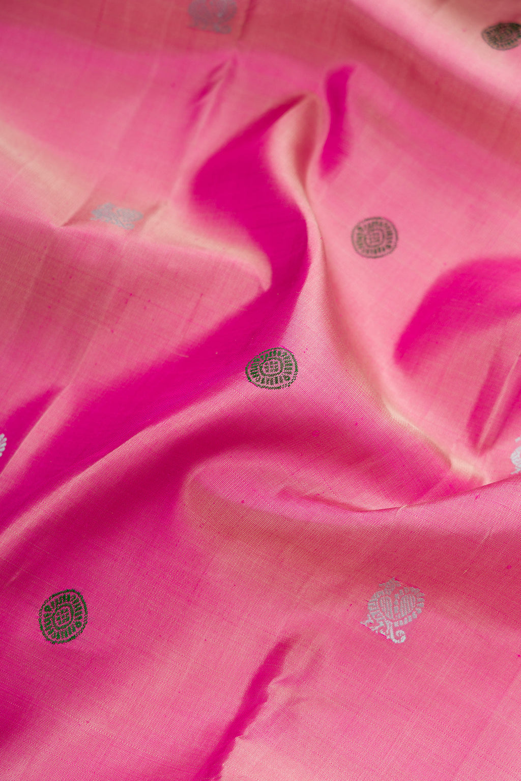 Close up of Pink Dual Tone Kanjivaram Silk Saree with Thread Butta on the body and Zari Border.  displaying folds