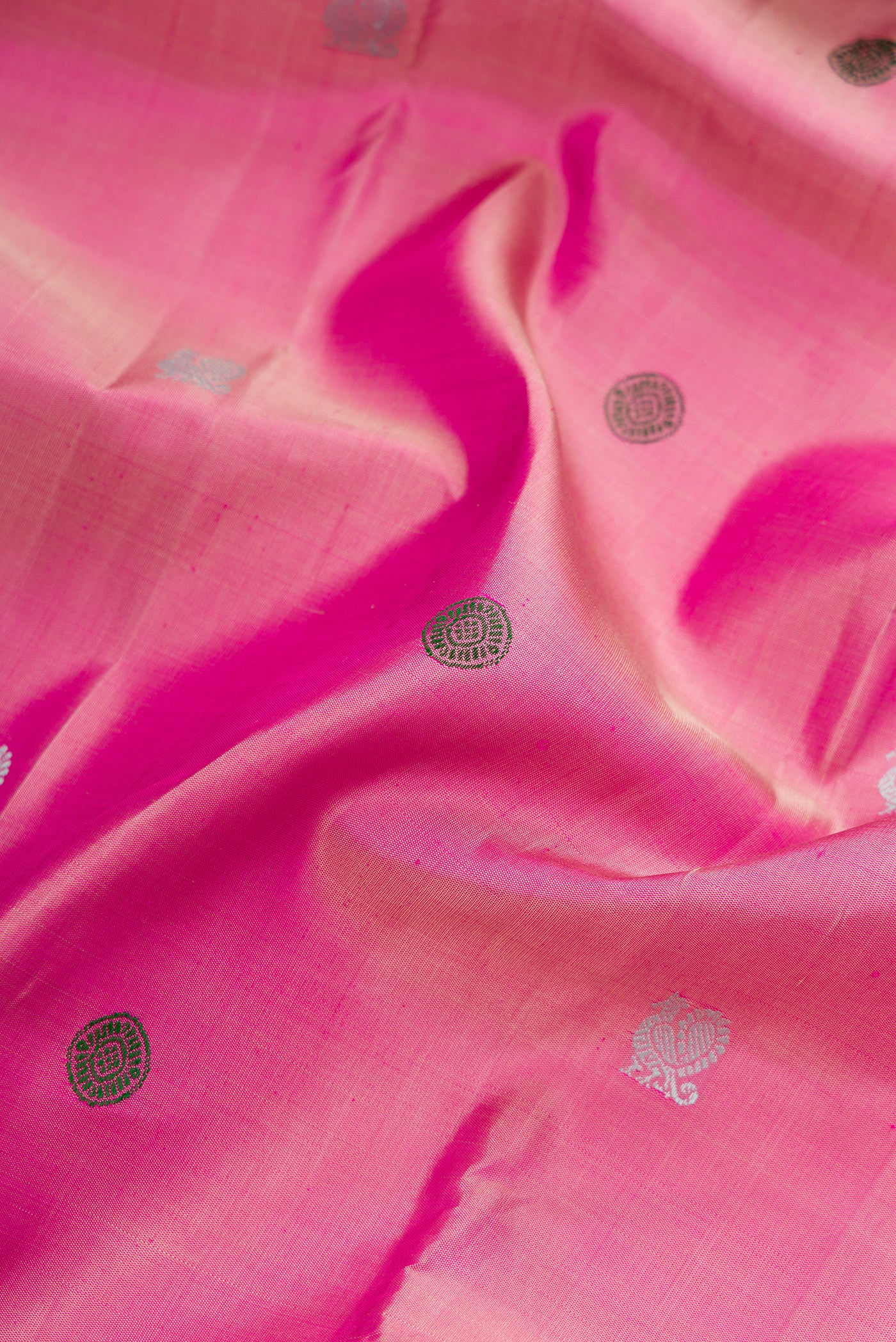 Close up of Pink Dual Tone Kanjivaram Silk Saree with Thread Butta on the body and Zari Border.  displaying folds