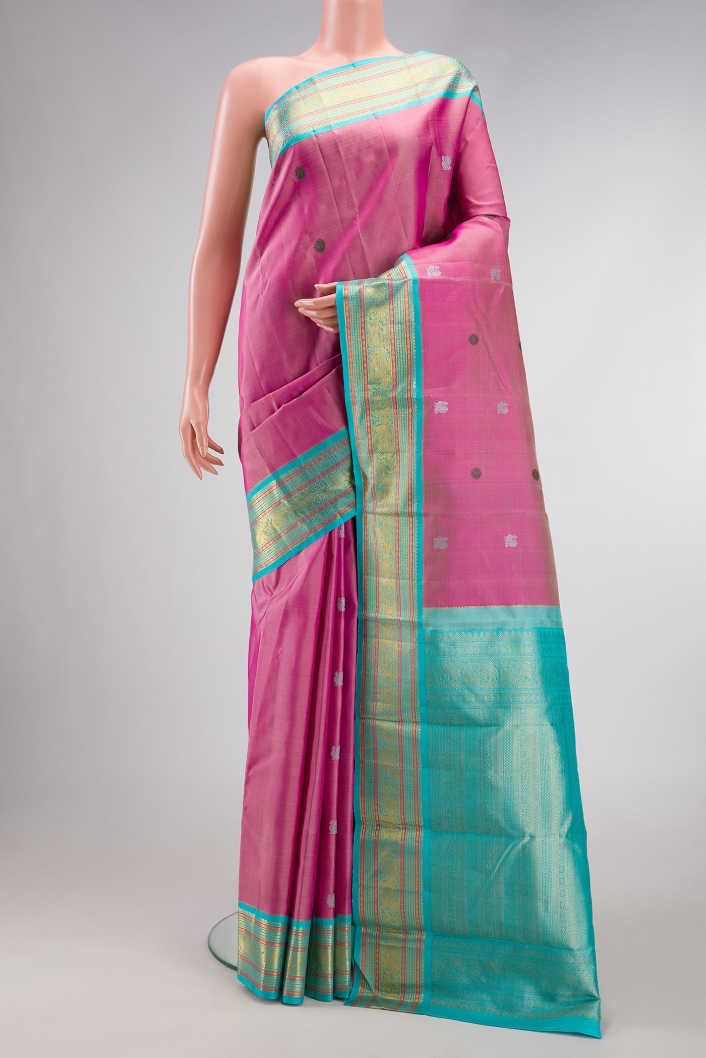 Pink Dual Tone Kanjivaram Silk Saree with Thread Butta on the body and Zari Border.  displayed on a mannequin