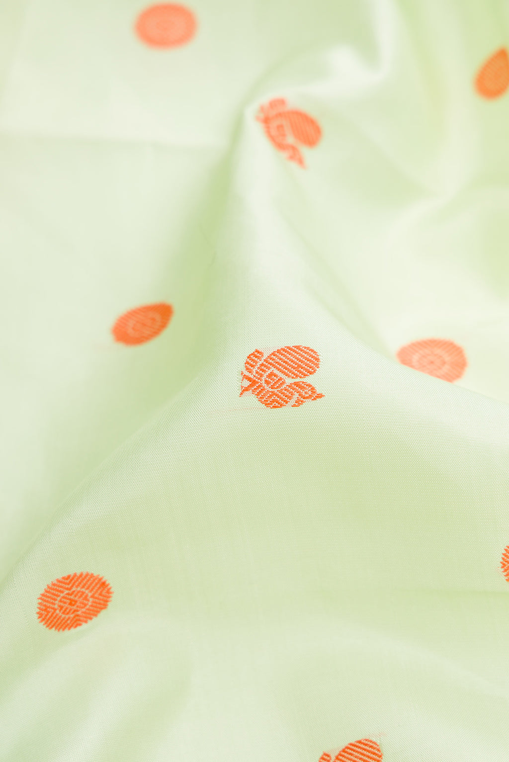 Close up of Pure Silk Pure Zari Pista Green Dual Tone Kanjivaram Saree with Thread Butta on the body and Zari Border.  displaying folds