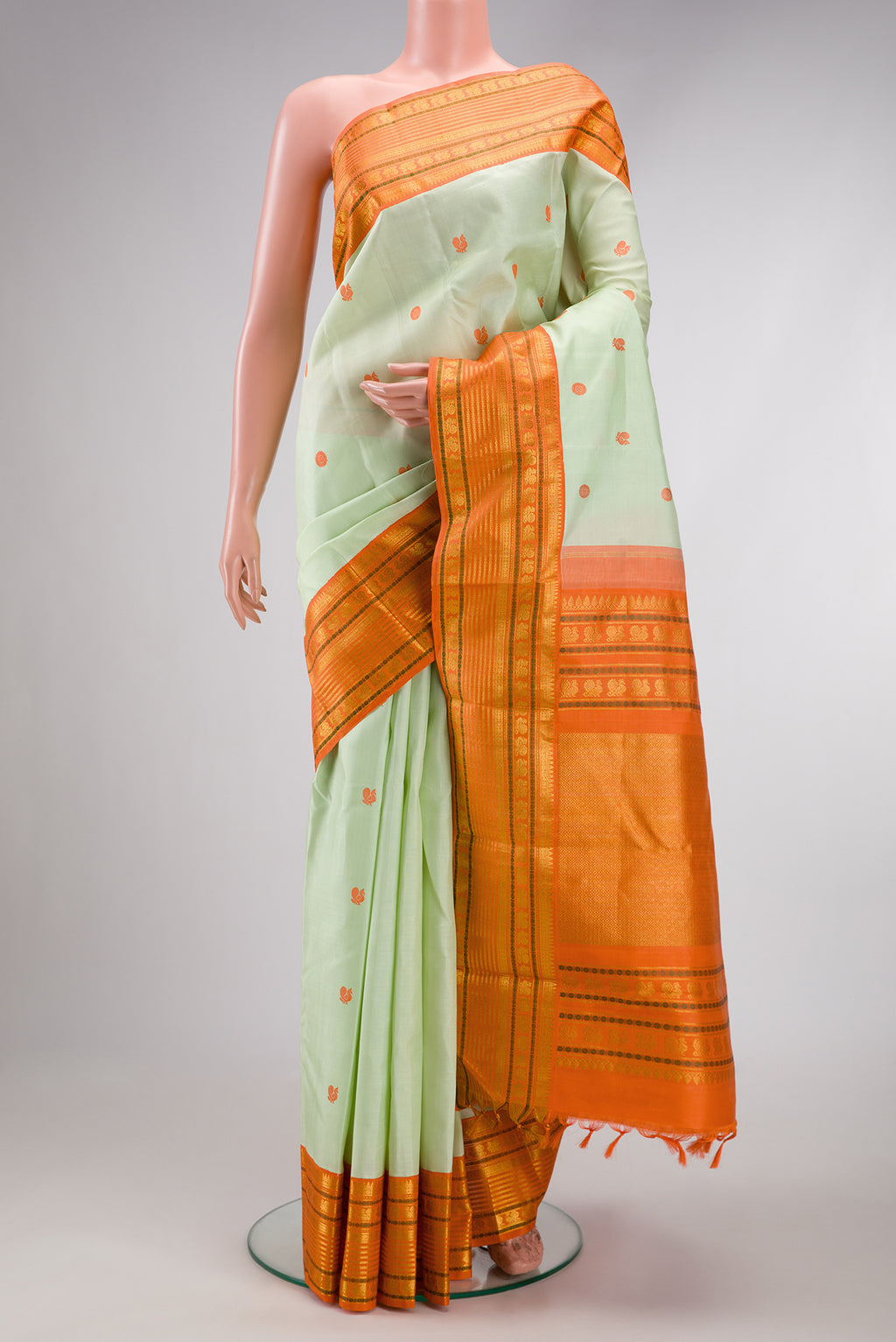 Pure Silk Pure Zari Pista Green Dual Tone Kanjivaram Saree with Thread Butta on the body and Zari Border.  displayed on a mannequin