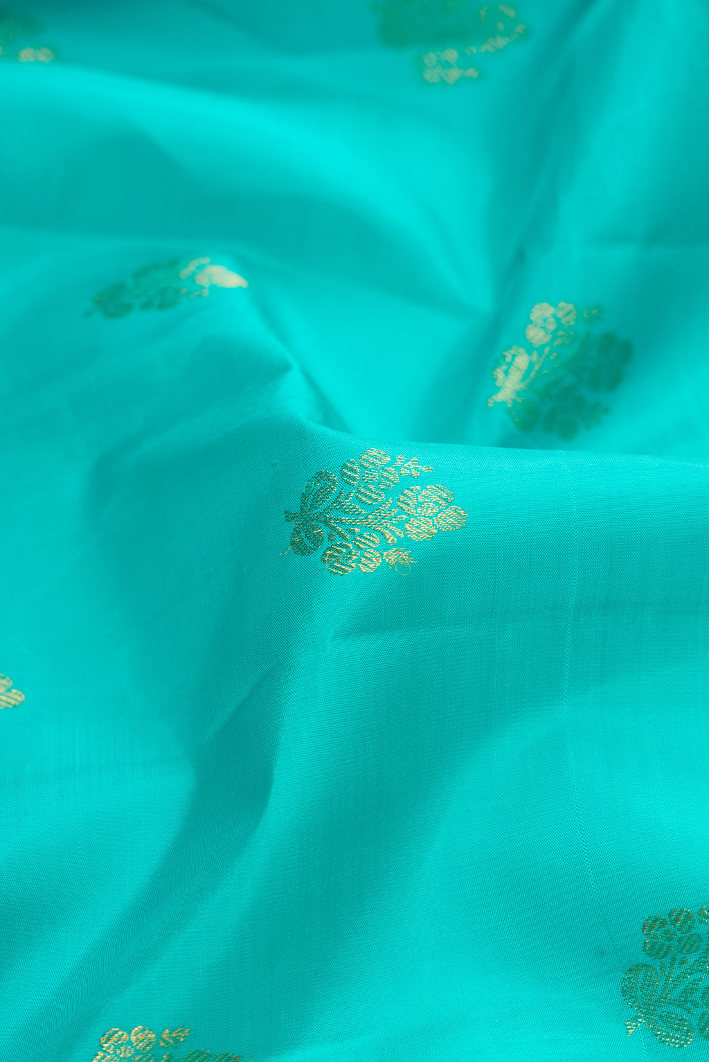 Close up of Sea Green Dual Tone Kanjivaram Silk Saree with Zari Butta on the body and Zari Border.  displaying folds