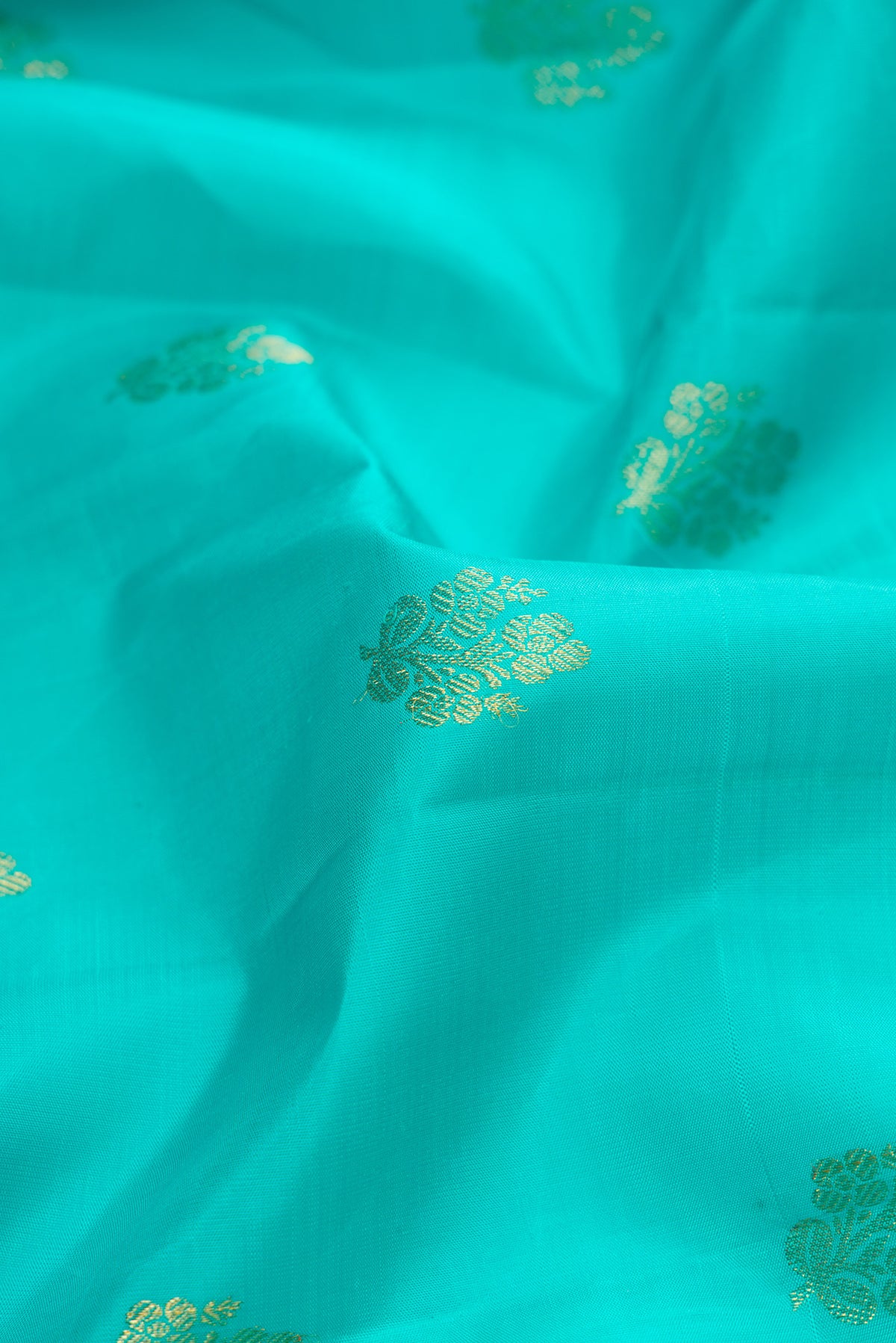 Close up of Sea Green Dual Tone Kanjivaram Silk Saree with Zari Butta on the body and Zari Border.  displaying folds