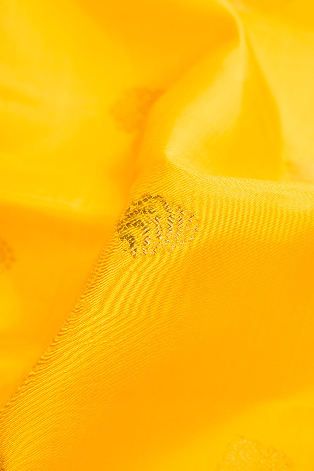 Close up of Pure Silk Pure Zari Yellow Dual Tone Kanjivaram Saree with Zari Butta on the body and Zari Border.  displaying folds
