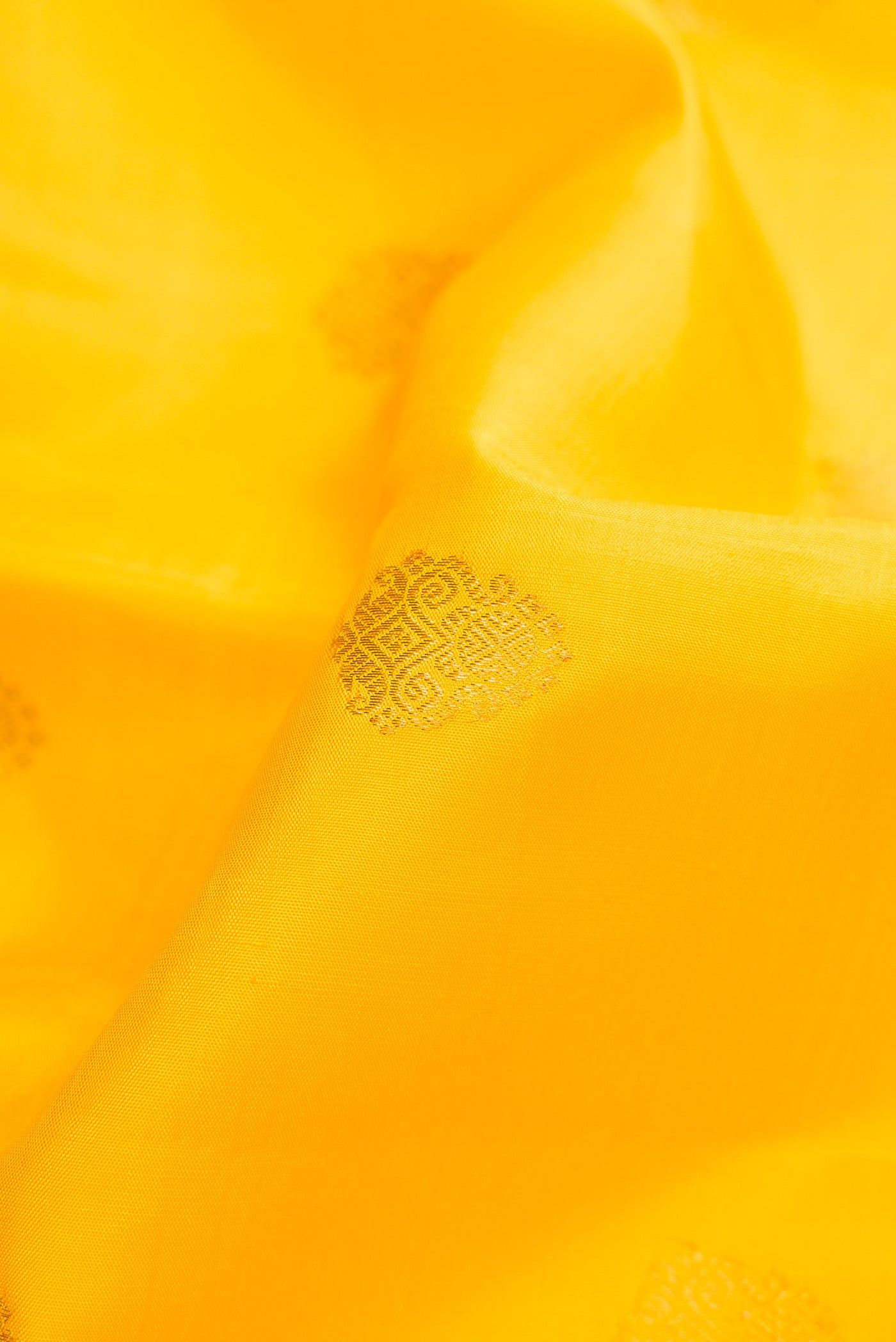 Close up of Pure Silk Pure Zari Yellow Dual Tone Kanjivaram Saree with Zari Butta on the body and Zari Border.  displaying folds