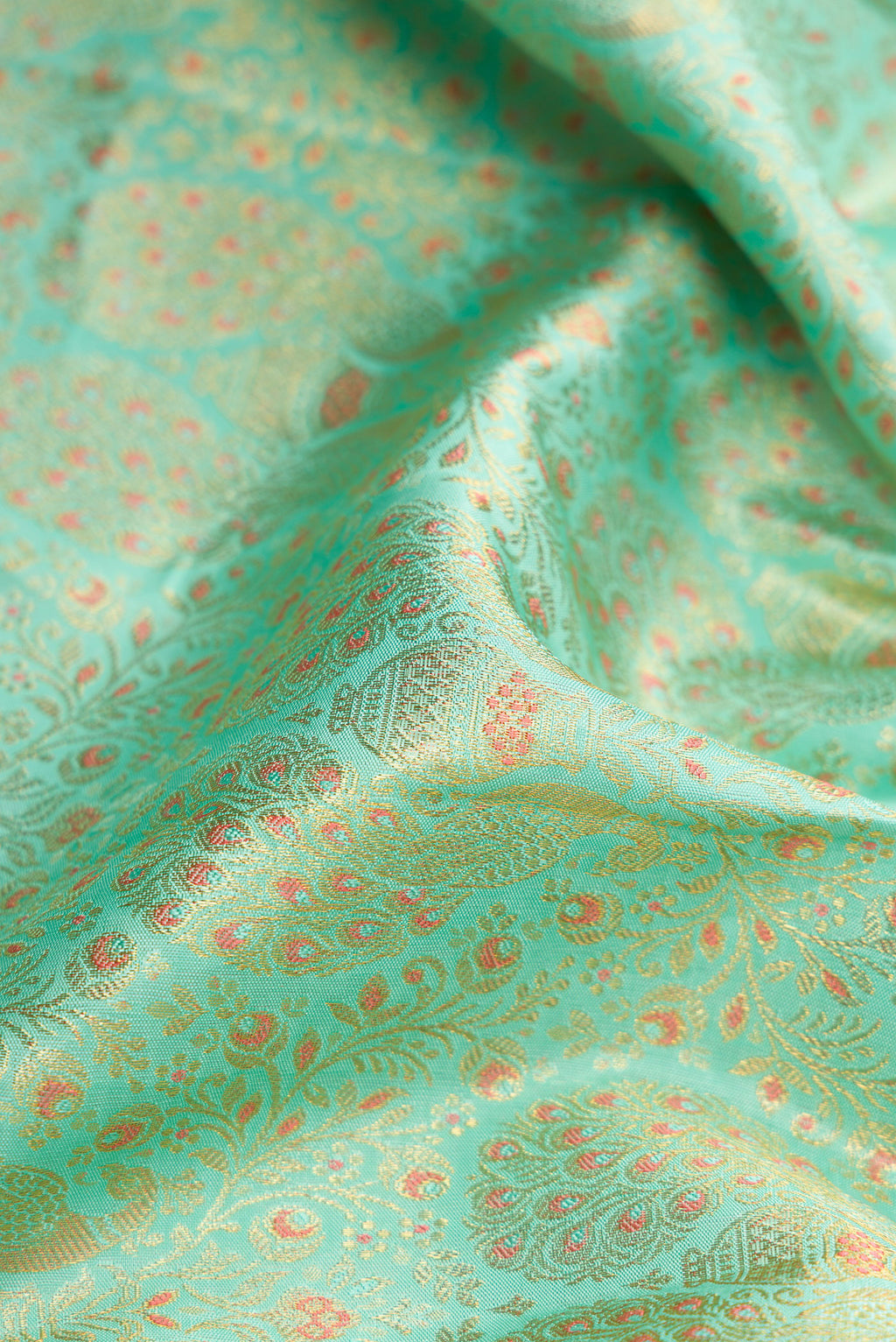 Close up of Pure Silk Pure Zari Sea Green Dual Tone Kanjivaram Saree with Zari Brocade on the body and Zari Border.  displaying folds