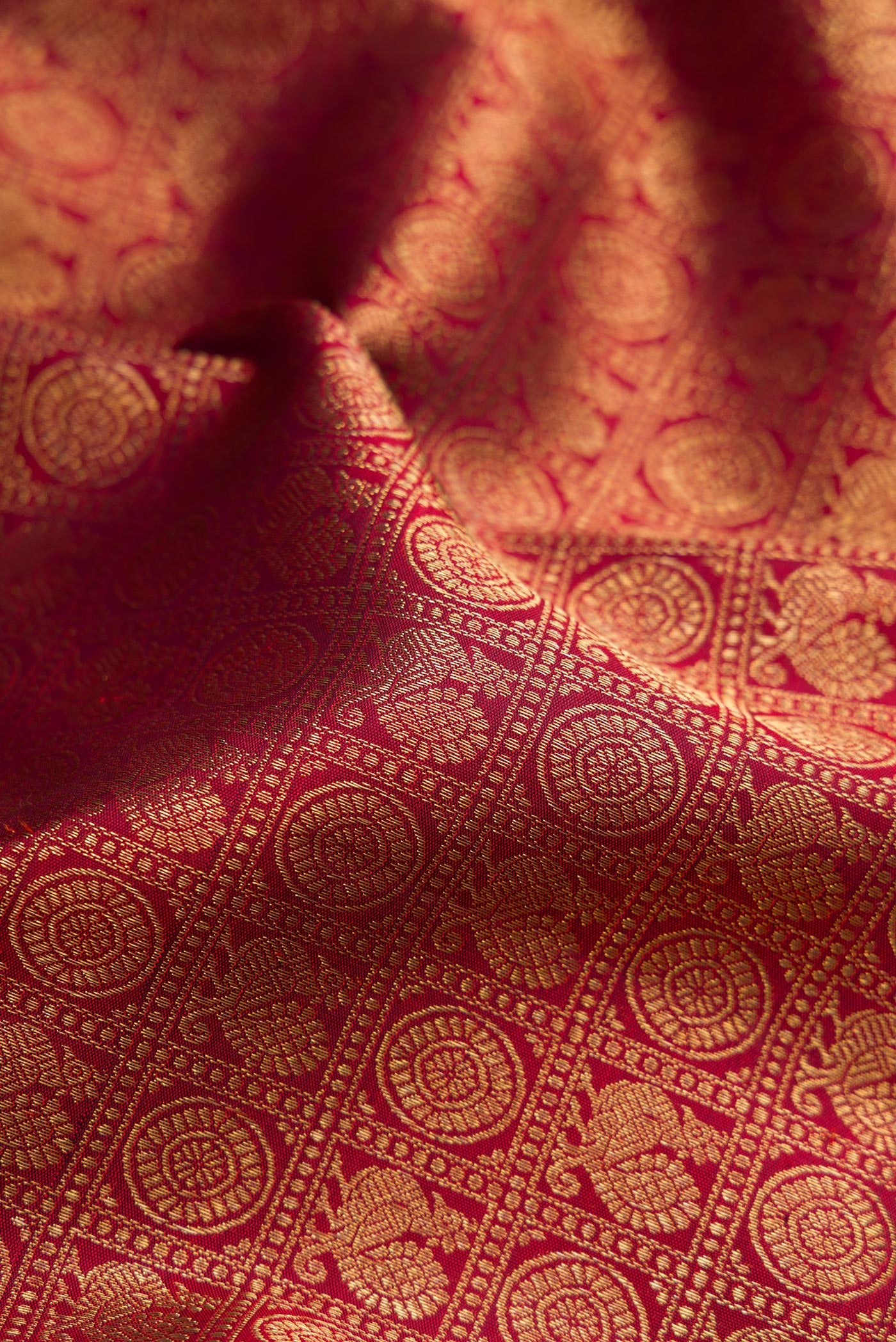 Close up of Pure Silk Pure Zari Maroon Kanjivaram Saree with Zari Brocade on the body and Zari Border.  displaying folds