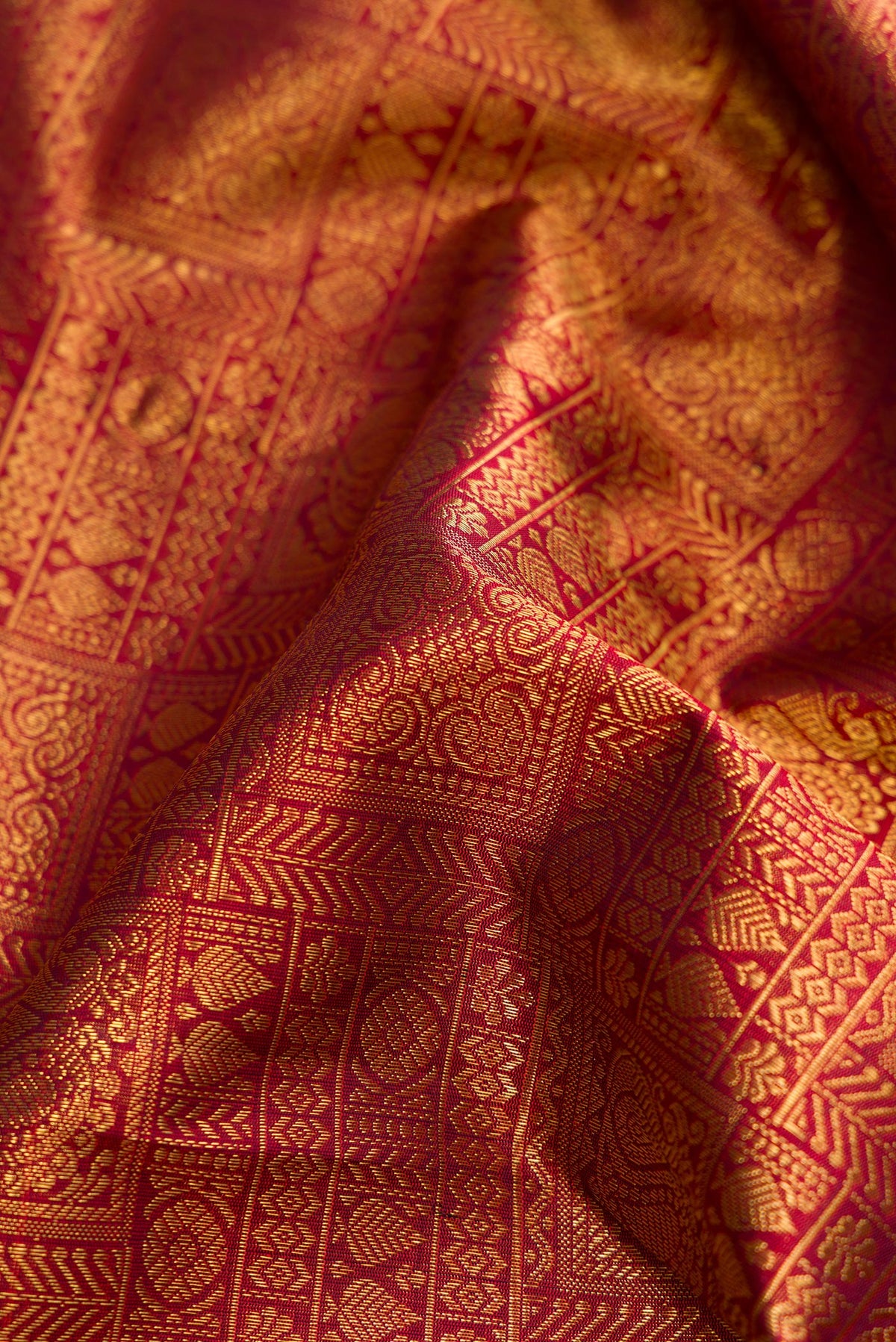 Close up of Pure Silk Pure Zari Maroon Kanjivaram Saree with Zari Brocade on the body and Zari Border.  displaying folds