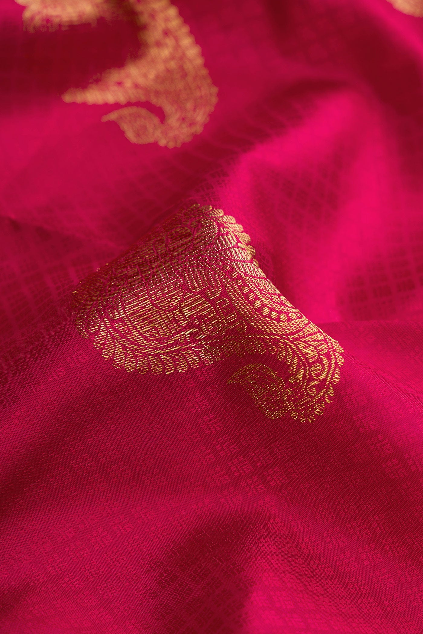 Close up of Pure Silk Pure Zari Maroon Dual Tone Kanjivaram Saree with Zari Butta on the body and Zari Border.  displaying folds
