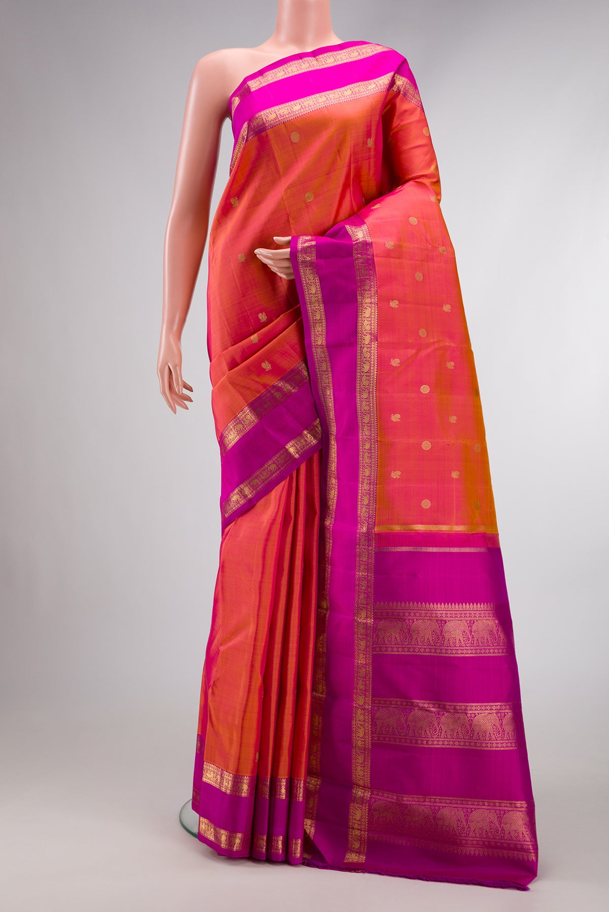 Pure Silk Pure Zari Coral Dual Tone Kanjivaram Saree with Zari Butta on the body and Zari Border.  displayed on a mannequin