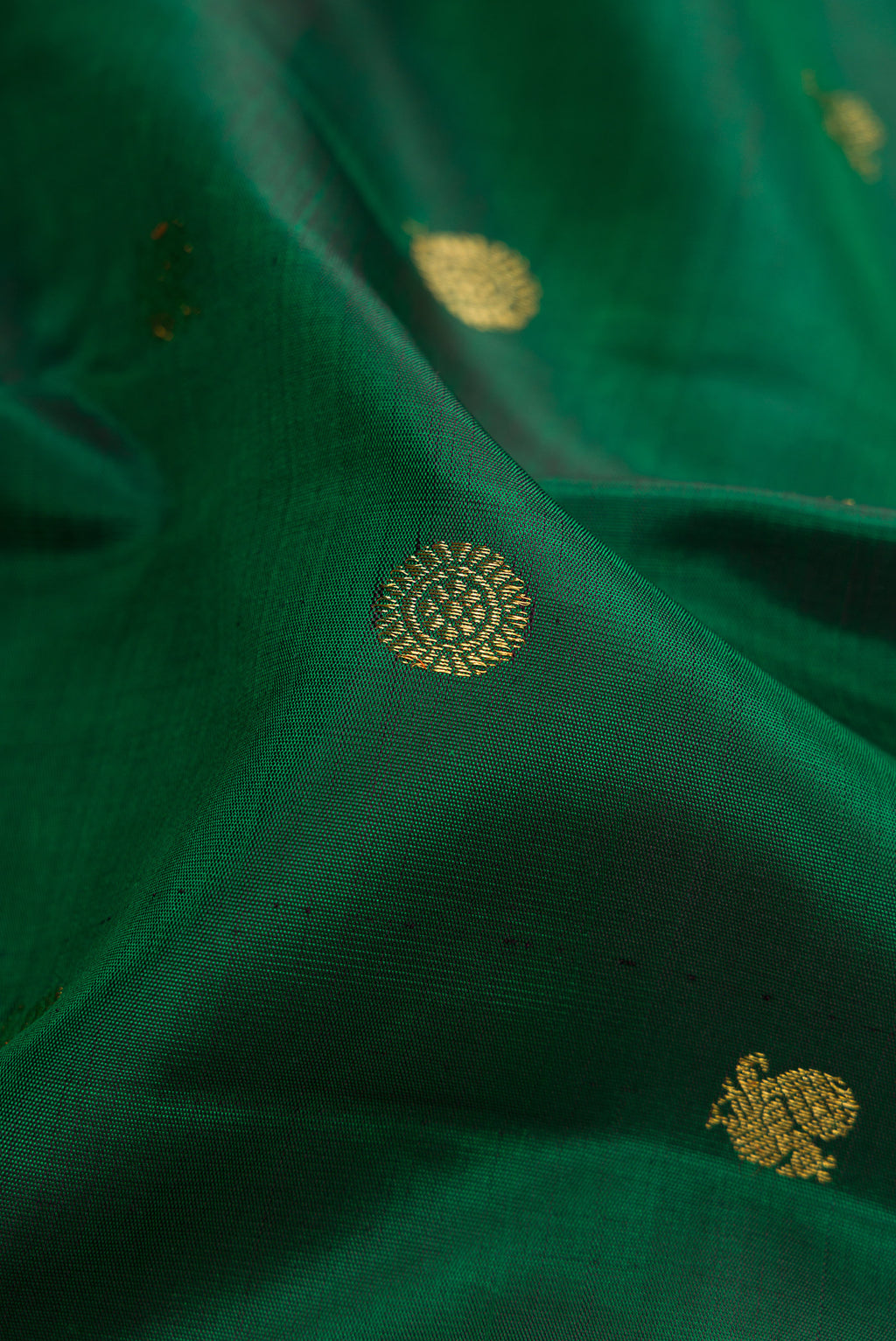 Close up of Pure Silk Pure Zari Green Dual Tone Kanjivaram Saree with Zari Butta on the body and Zari Border.  displaying folds