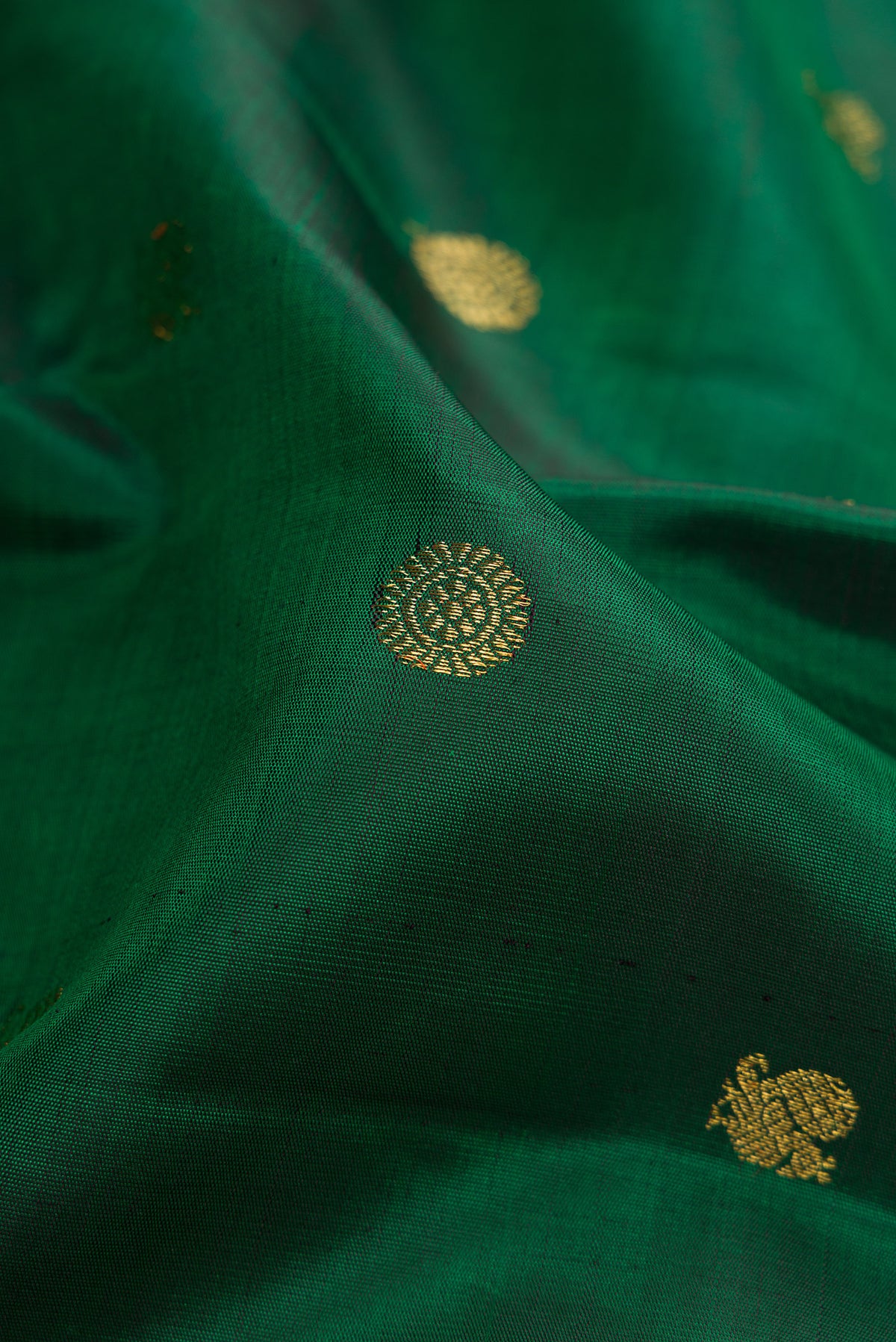 Close up of Pure Silk Pure Zari Green Dual Tone Kanjivaram Saree with Zari Butta on the body and Zari Border.  displaying folds