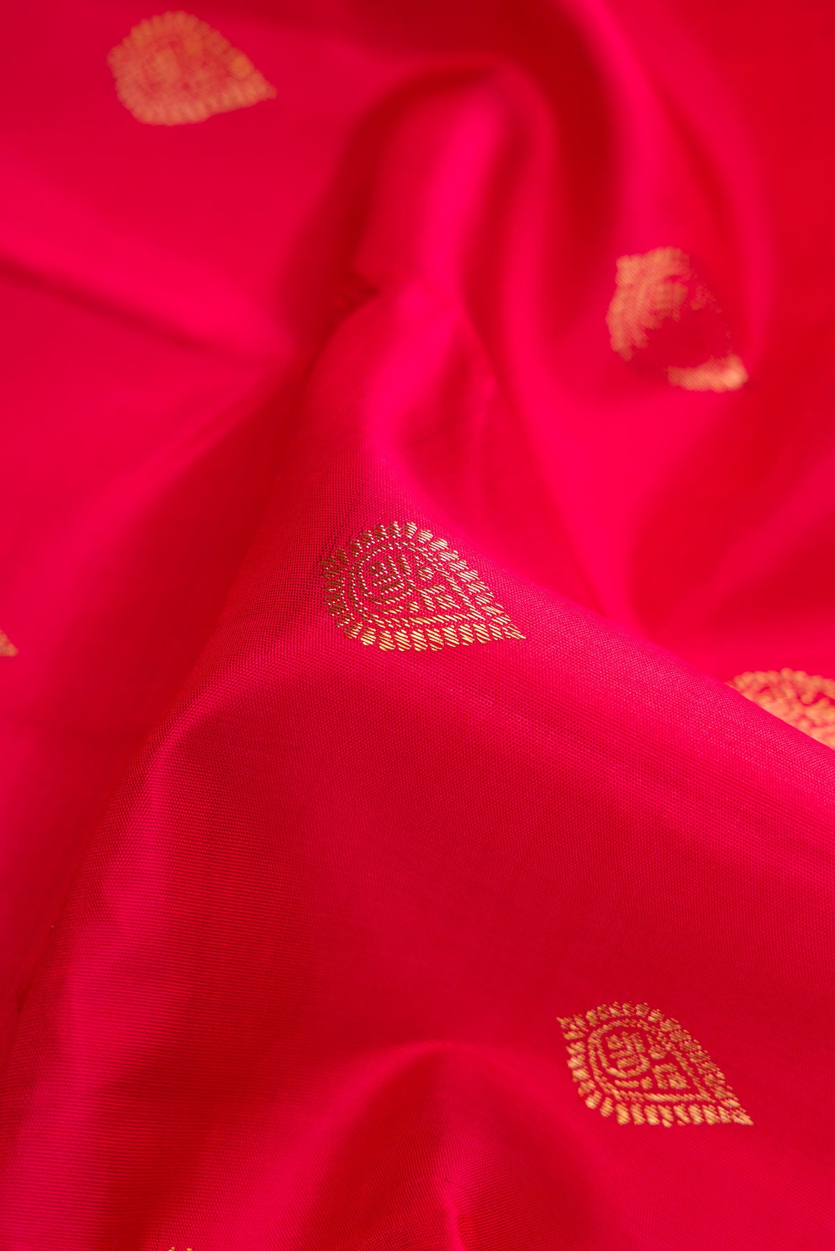 Close up of Red Dual Tone Kanjivaram Silk Saree with Zari Butta on the body and Zari Border.  displaying folds