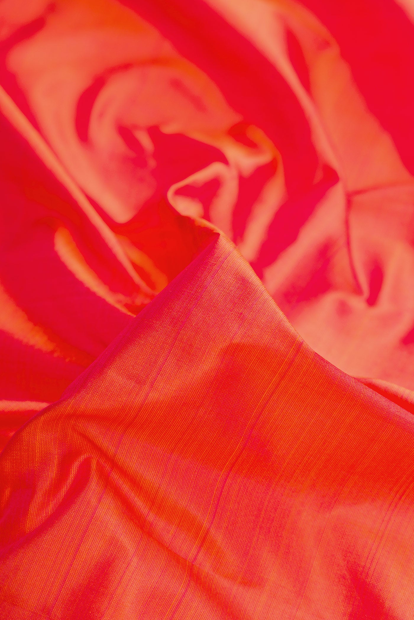 Close up of Coral Dual Tone Kanjivaram Silk Saree with Plain Body and Zari Border.  displaying folds