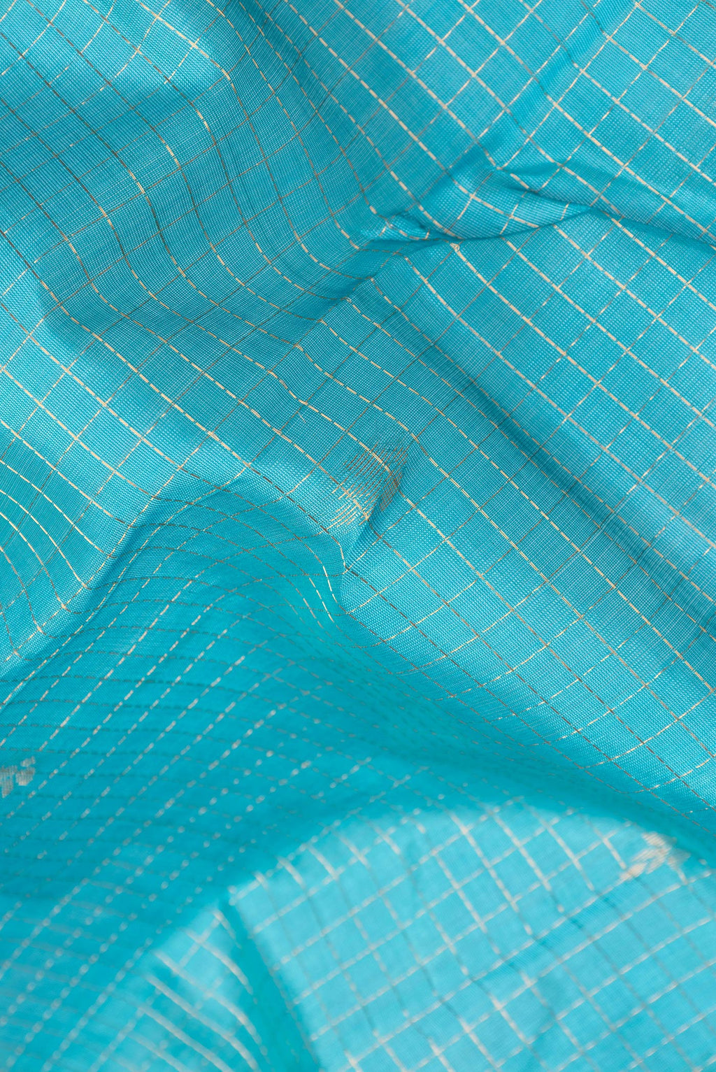 Close up of Sky Blue Silk Cotton Saree with Checked design on the body and Zari Border.  displaying folds