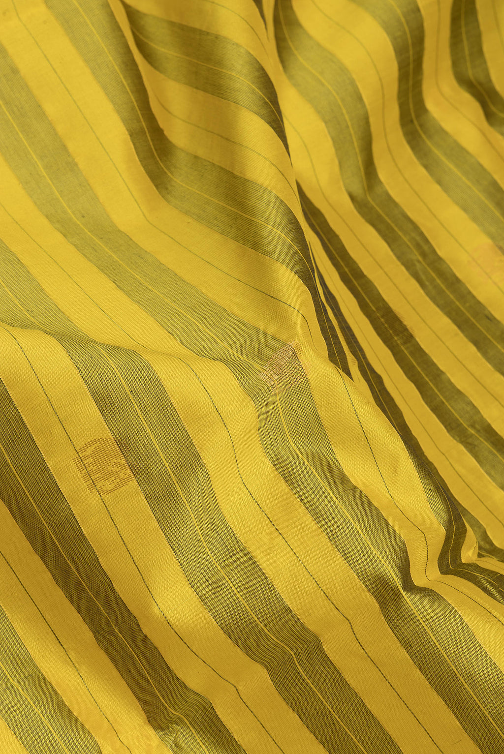 Close up of Yellow Silk Cotton Saree with Stripes on the body and Zari Border.  displaying folds