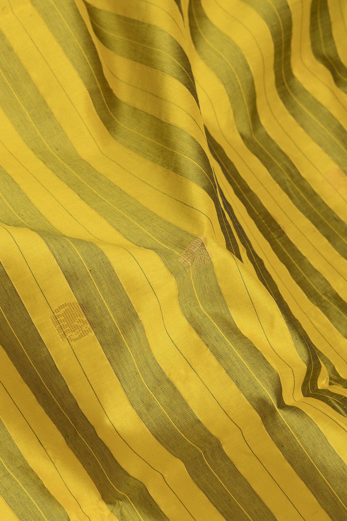 Close up of Yellow Silk Cotton Saree with Stripes on the body and Zari Border.  displaying folds