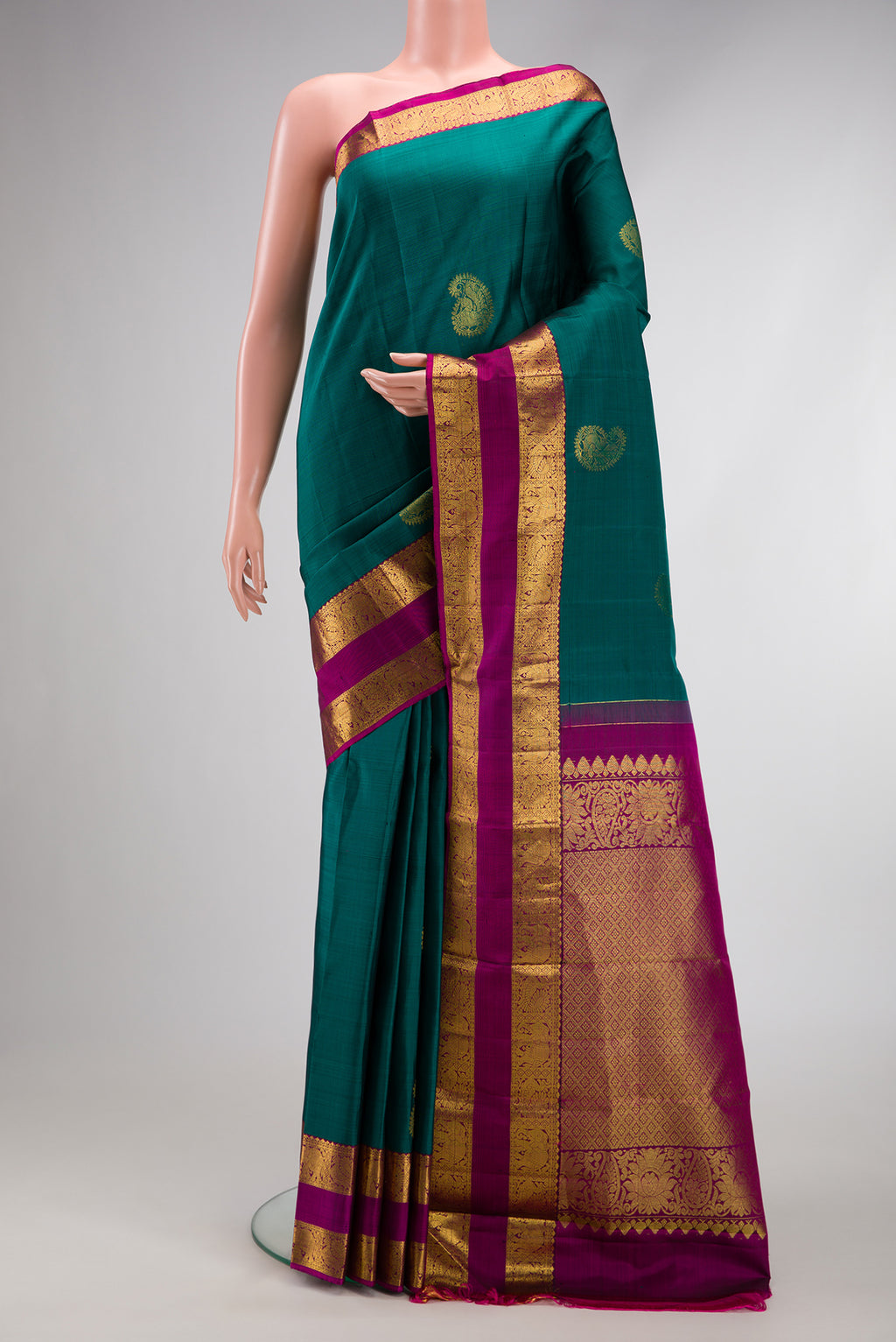 Green Dual Tone Kanjivaram Silk Saree with Zari Butta on the body and Zari Border.  displayed on a mannequin